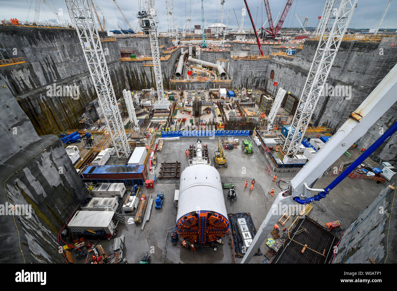 EMBARGOED TO 0001 FRIDAY 28th JUNE A massive tunnel boring machine in the foreground and huge water cooling pipes sit on the deep dig excavation heat-sink site at Hinkley Point C where the UK's largest ever concrete pour, around 9'000M3, is taking place during the construction of the surrounds for the nuclear reactor at the power station near Bridgwater, Somerset. The pour beat the previous largest which was during construction of The Shard in London. Stock Photo