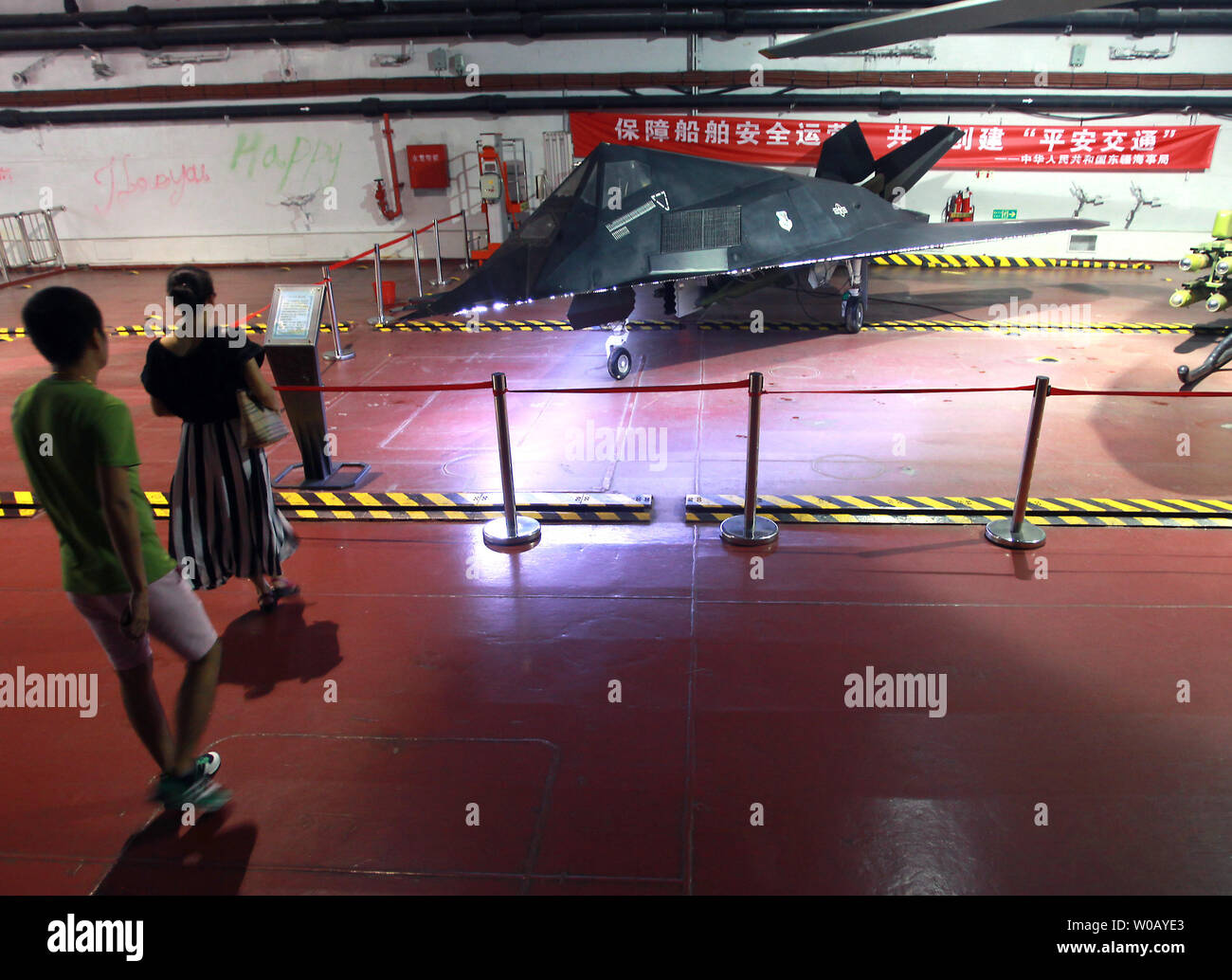 Chinese tourists visit the Binhai Aircraft Carrier Theme Park, featuring the ex-Russian heavy aircraft cruiser the Kiev with a small-scale model of a U.S. stealth fighter, in Tianjin on July 29, 2014.  The Kiev was a heavy aircraft-carrying cruiser that served the Soviet and Russian navies from 1975 to 1993 before being sold to a Chinese company in 1996 for use in a military theme park.  Over $15.5 million was spent restoring and outfitting the ex-warship into a luxury hotel developed by tourism and attraction consultant Leisure Quest International (USA).      UPI/Stephen Shaver Stock Photo