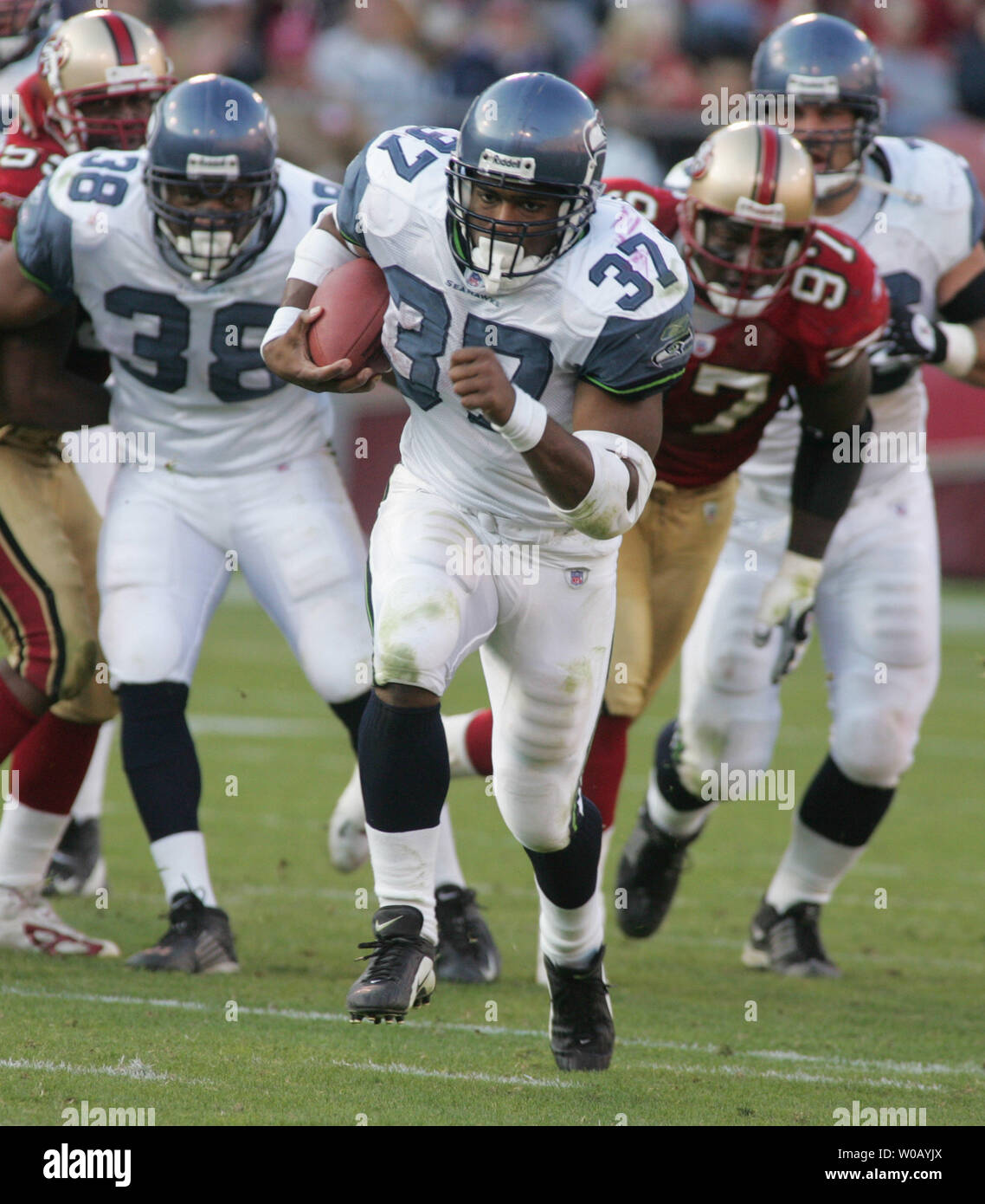 Seattle Seahawks running back Shaun Alexander (37) is tacked by Green Bay  Packers safety Atari Bigby (20) for a 1-yard loss during the first quarter  of the NFC Divisional Playoff at Lambeau