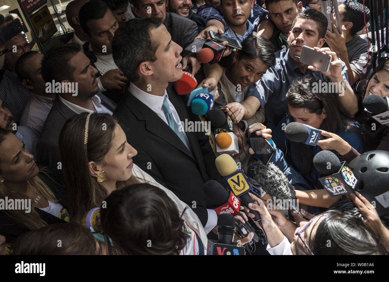 Opposition leader and self-proclaimed 'acting president' Juan Guaido (C) talks to the press as he holds his daughter Miranda, next to his wife Fabiana Rosales (L), outside his home in Santa Fe, Caracas on January 31, 2019. Venezuela's opposition leader Juan Guaido was to outline his plans to tackle the country's economic crisis Thursday after European lawmakers recognized him as the acting head of state -- another step forward in his bid to force out President Nicolas Maduro. photo by Marcelo Perez/ UPI Stock Photo