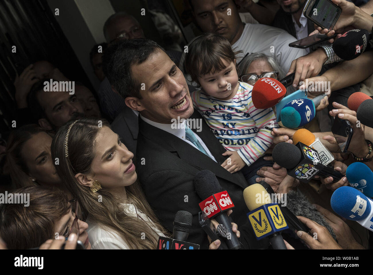 Opposition leader and self-proclaimed 'acting president' Juan Guaido (L) talks to the press as he holds his daughter Miranda, next to his wife Fabiana Rosales , outside his home in Santa Fe, Caracas on January 31, 2019. Venezuela's opposition leader Juan Guaido was to outline his plans to tackle the country's economic crisis Thursday after European lawmakers recognized him as the acting head of state -- another step forward in his bid to force out President Nicolas Maduro. photo by Marcelo Perez/ UPI Stock Photo