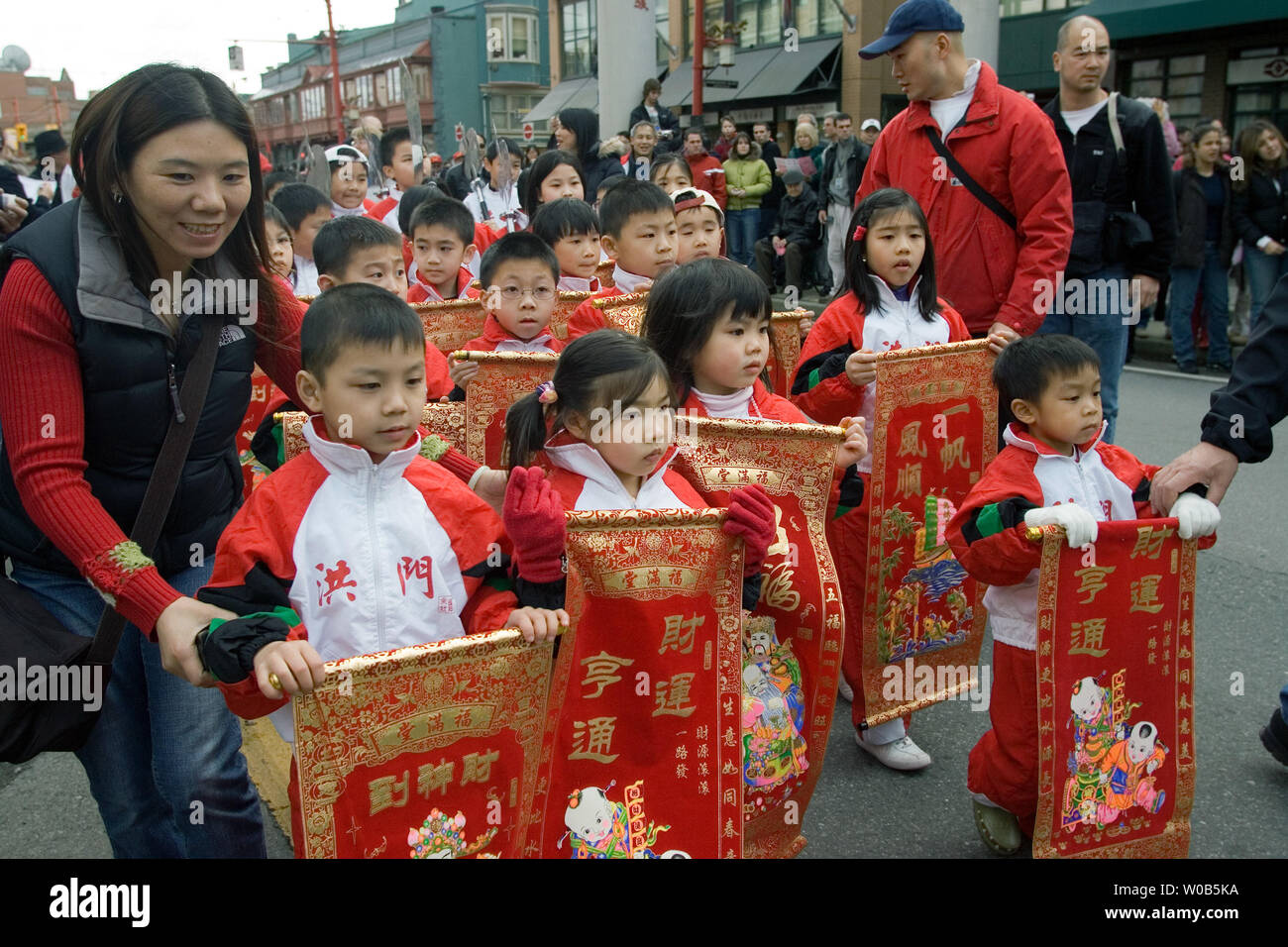Children carrying banners bringing good luck and prosperity are guided through Chinatown during the Chinese New Year Parade celebrating the Year of the Boar in Vancouver, B.C., February 18, 2007. Crowds numbering in the tens of thousands turn out for this event.  (UPI Photo/Heinz Ruckemann) Stock Photo