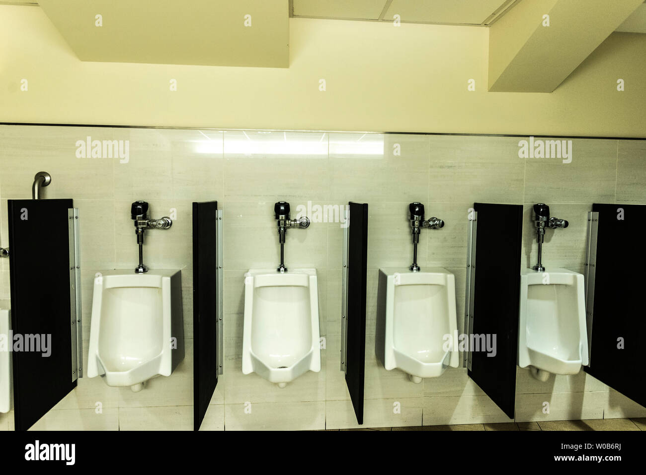 Four WC or urinal for men inside a building in New York City, USA Stock Photo