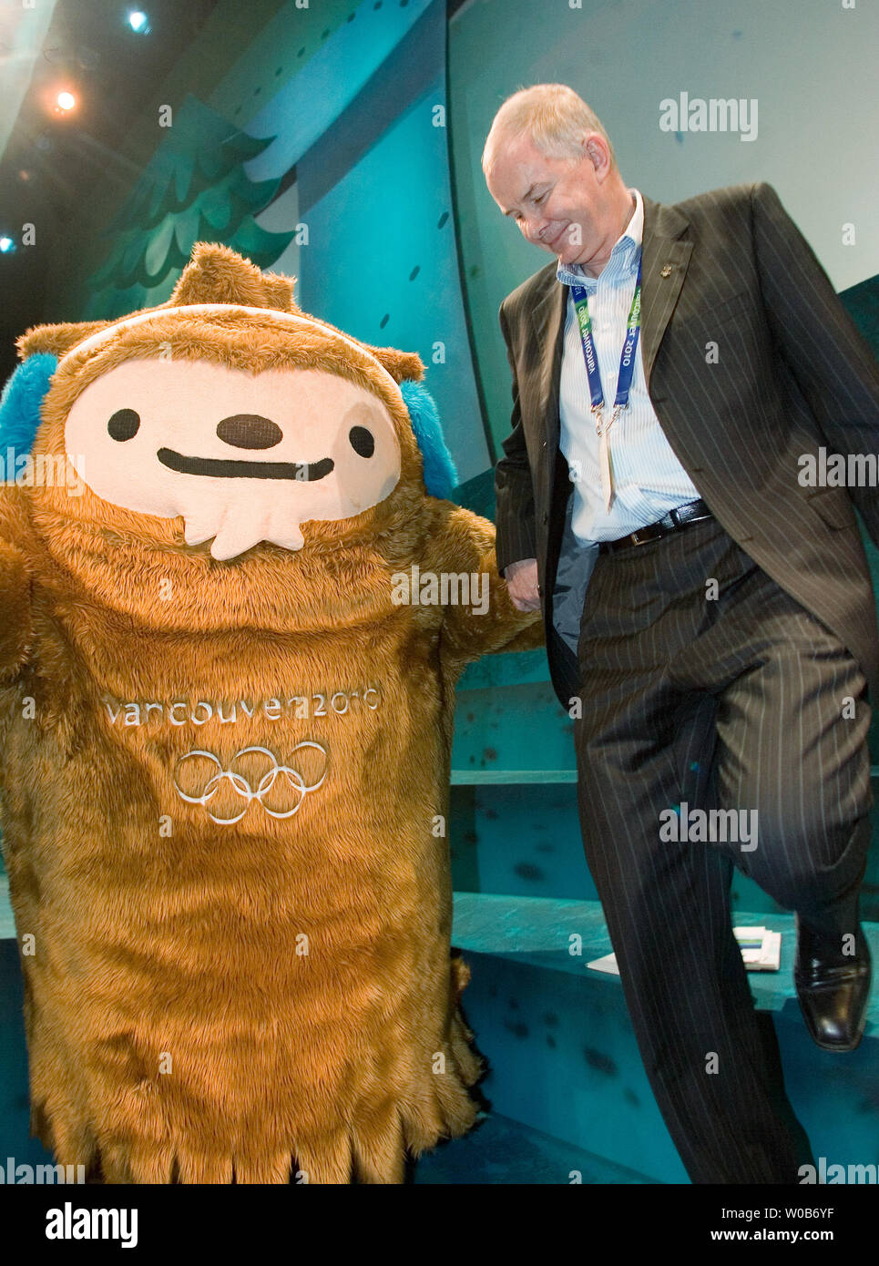 VANOC CEO John Furlong helps Quatchi down some steps onstage at the unveiling of the 2010 Winter Olympic Mascots Miga, Quatchi and Sumi in Surrey near Vancouver, British Columbia, November 27, 2007. Miga is a sea bear which according to First Nations legend is an orca whale which can turn into the rare white Kermode bear only found in British Columbia. Quatchi is a sasquatch described in many West Coast First Nations stories but rarely seen. Sumi is an animal gaurdian spirit who wears the hat of an orca, has the strong leags of the black bear and flies with the wings of the great thunderbird. Stock Photo