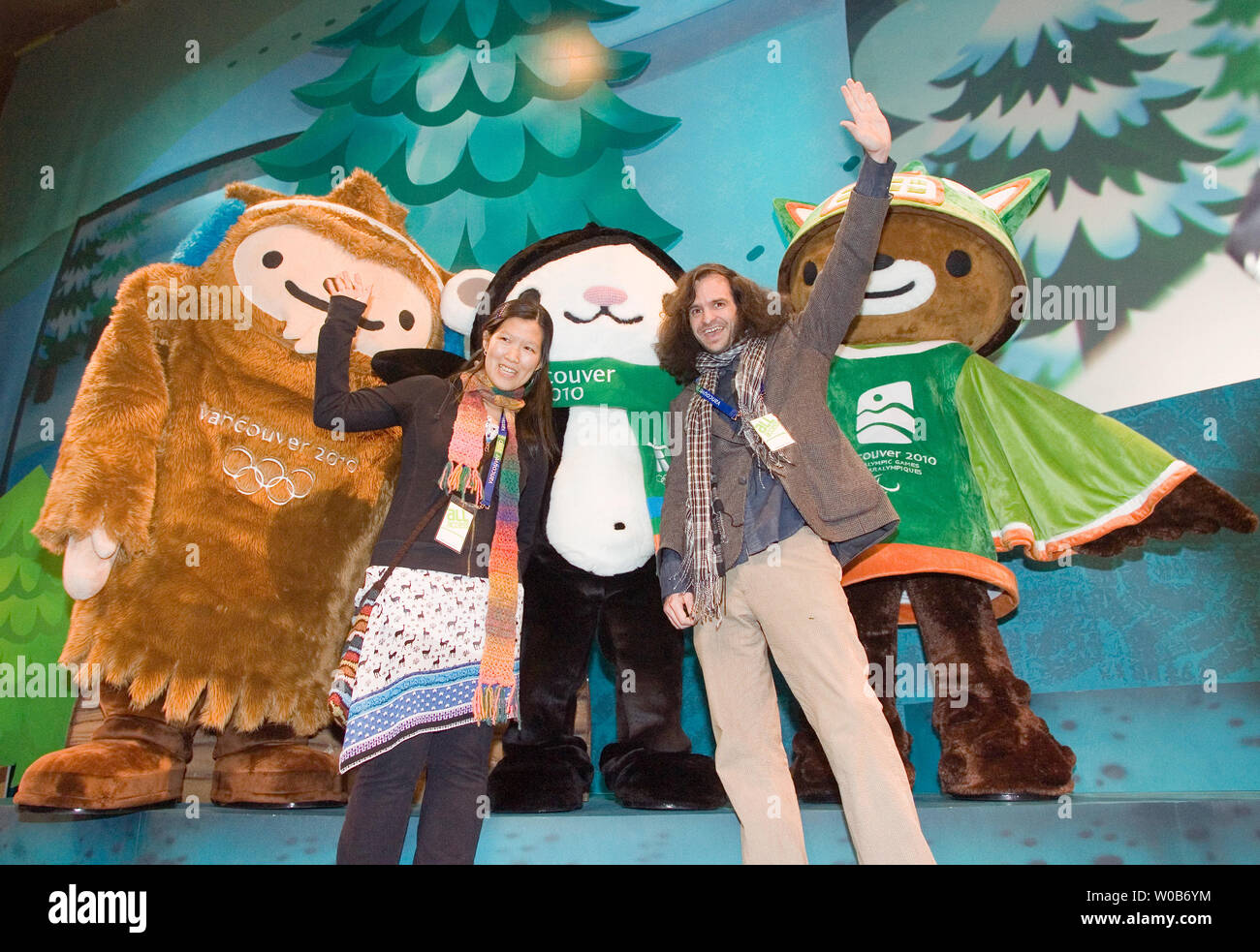 The 2010 Winter Olympic Mascot design winners Vicki Wong (L) and Michael Murphy of Meomi Design wave in front of their creations Quatchi (L), Miga and Sumi (R) at their unveiling in Surrey near Vancouver, British Columbia, November 27, 2007. Miga is a sea bear which according to First Nations legend is an orca whale which can turn into the rare white Kermode bear only found in British Columbia. Quatchi is a sasquatch described in many West Coast First Nations stories but rarely seen. Sumi is an animal gaurdian spirit who wears the hat of an orca, has the strong leags of the black bear and flie Stock Photo