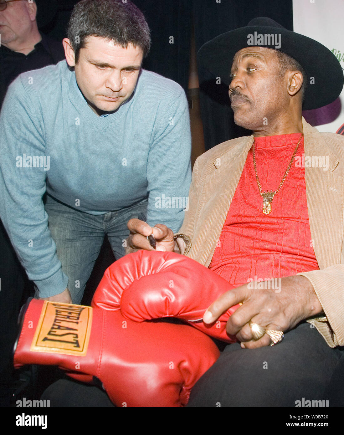 Smokin' Joe Frazier autographs former boxer and current trainer and promoter Manny Sobral's gloves during the Rumble at the Rock III press conference in the River Rock Casino near Vancouver, British Columbia, December 27, 2007. Televised live on ESPN 'Friday Night Fights,' tomorrow night's fights will be headlined by a ten round heavyweight match between Dominick Guinn based out of Houston, Texas and Robert Hawkins from Philadelphia, Pennsylvania.    (UPI Photo/Heinz Ruckemann) Stock Photo