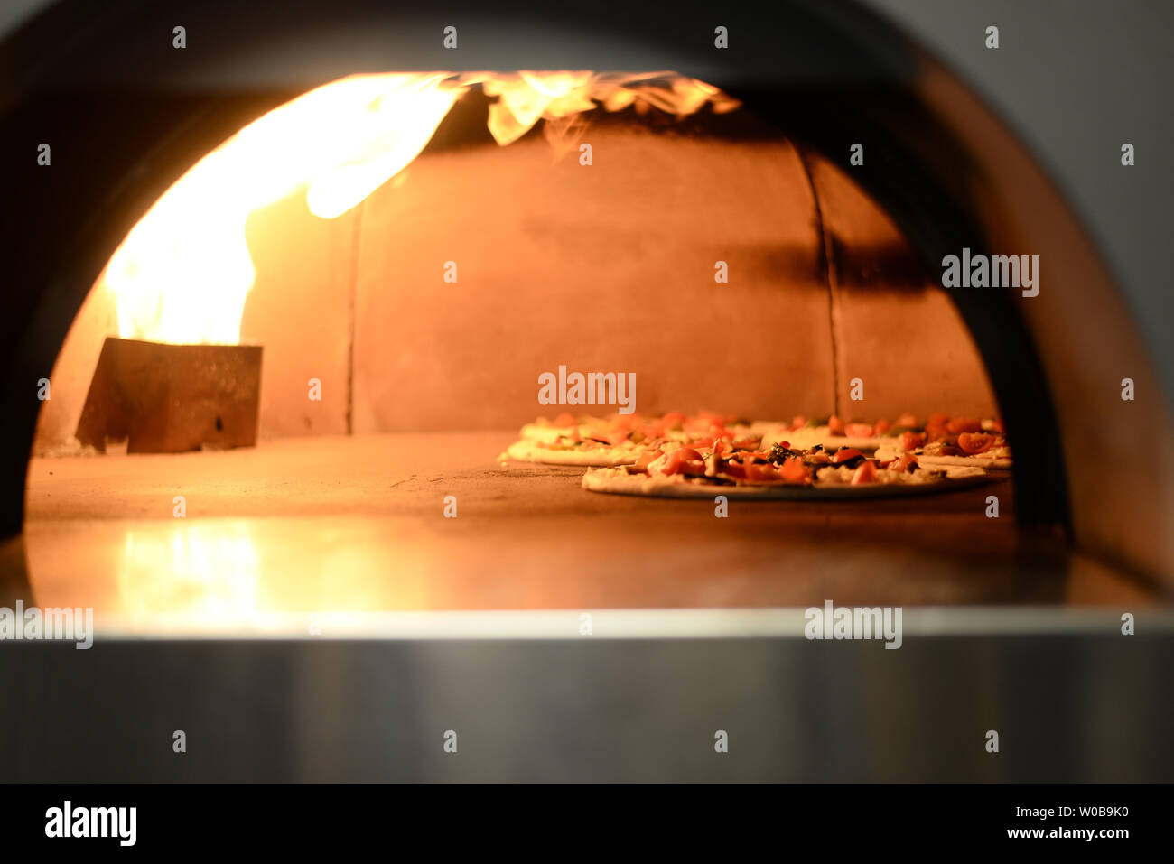 Pizza being made in gas fired pizza oven Stock Photo Alamy