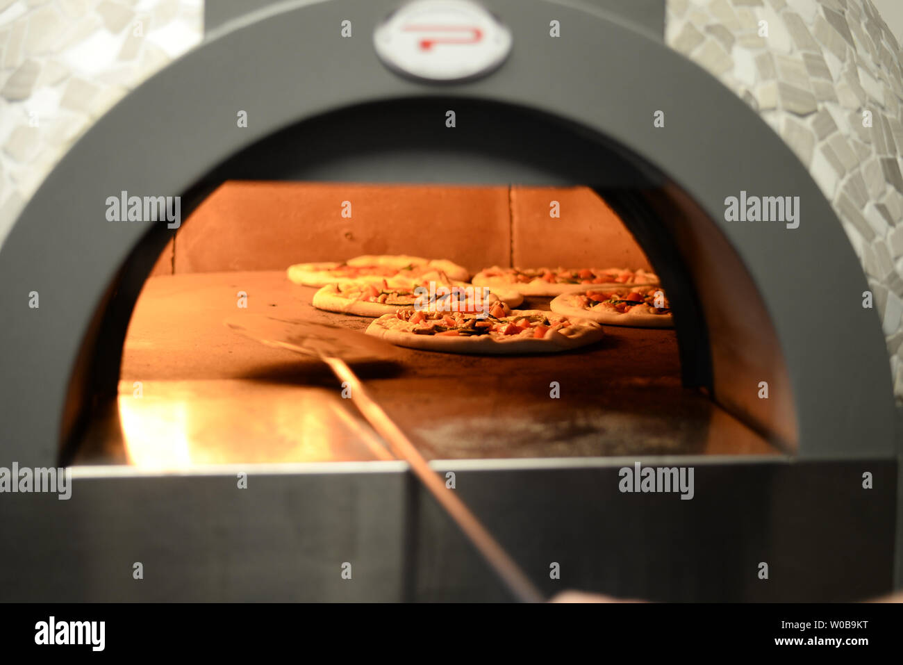 Pizza being made in gas fired pizza oven Stock Photo Alamy