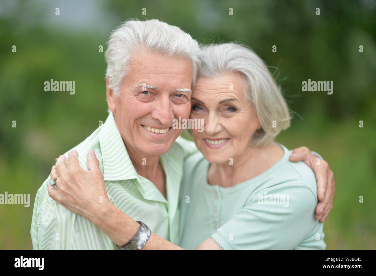 Beautiful senior couple posing and hugging in the park Stock Photo - Alamy