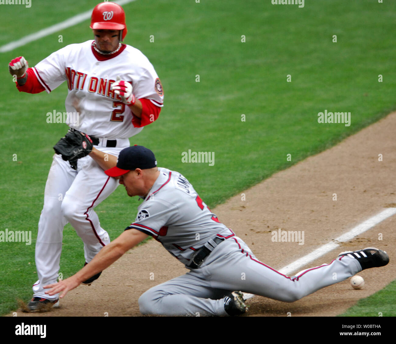 Washington Nationals shortstop Felipe Lopez (2) scores on a bases loaded single by Washington Nationals right fielder Austin Kearns as Atlanta Braves pitcher Chuck James (R) fails to handle the ball in the fifth inning at RFK Stadium in Washington on May 17, 2007.  The Nationals defeated the Braves 4-3.  (UPI Photo/Mark Goldman) Stock Photo