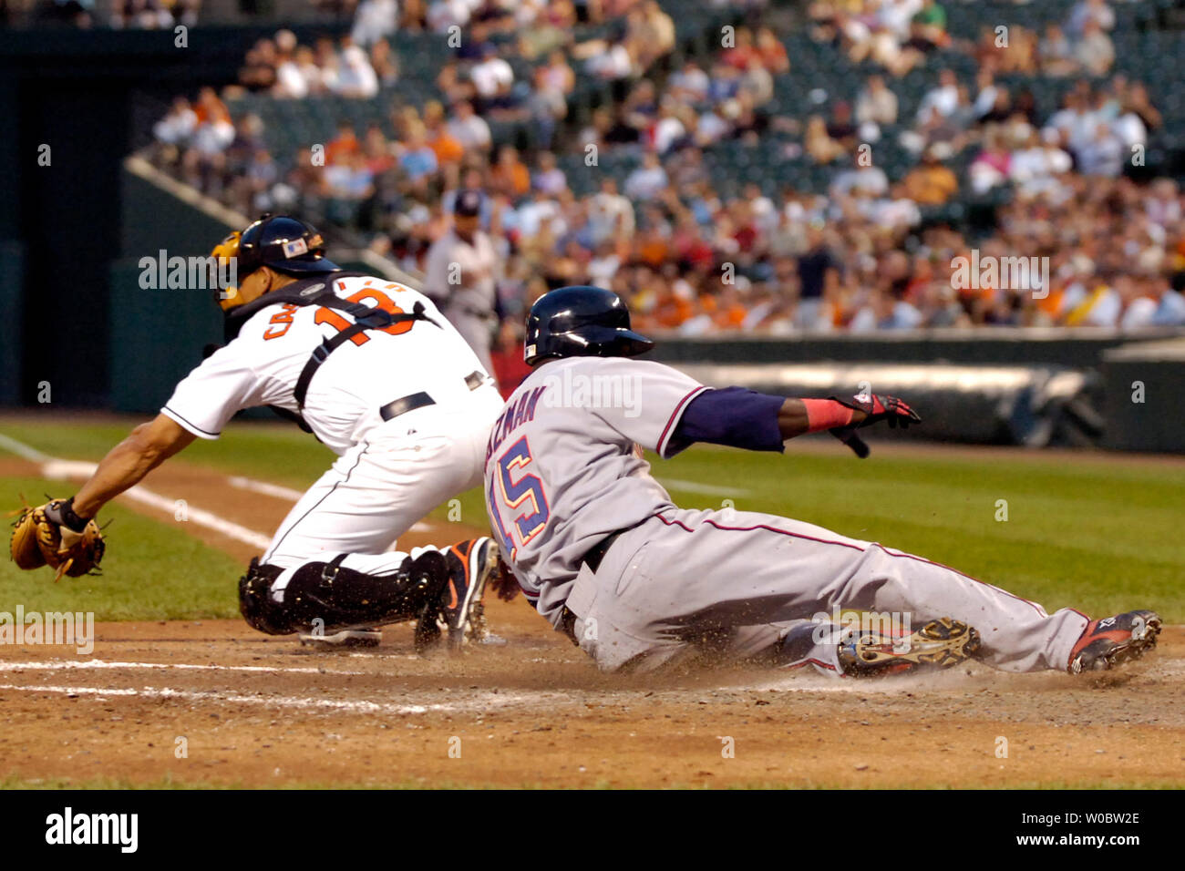 Washington Nationals shortstop Cristian Guzman (R) safely slides home after second baseman Felipe Lopez hit a two-run RBI double in the fourth inning against Baltimore Orioles pitcher Daniel Cabrera on June 12, 2007 at Orioles Park at Camden Yards in Baltimore.  (UPI Photo/Mark Goldman) Stock Photo