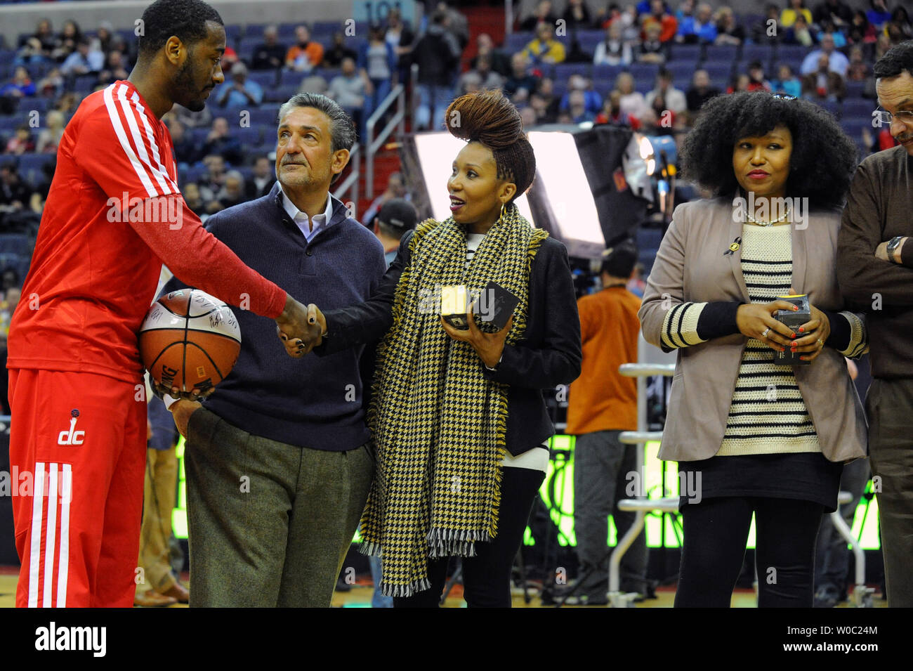 Standing (L-R) Washington Wizards point guard John Wall, founder, chairman, majority owner and CEO of Monumental Sports & Entertainment Ted Leonsis Princesses Swati and Zaziwe (R) Mandela, granddaughters of the late Nelson Mandela, and  District of Columbia mayor Vincent Gray as they present both teams with limited edition Mandela Bangles at the Verizon Center in Washington, D.C. on December 28, 2013.   UPI/Mark Goldman Stock Photo