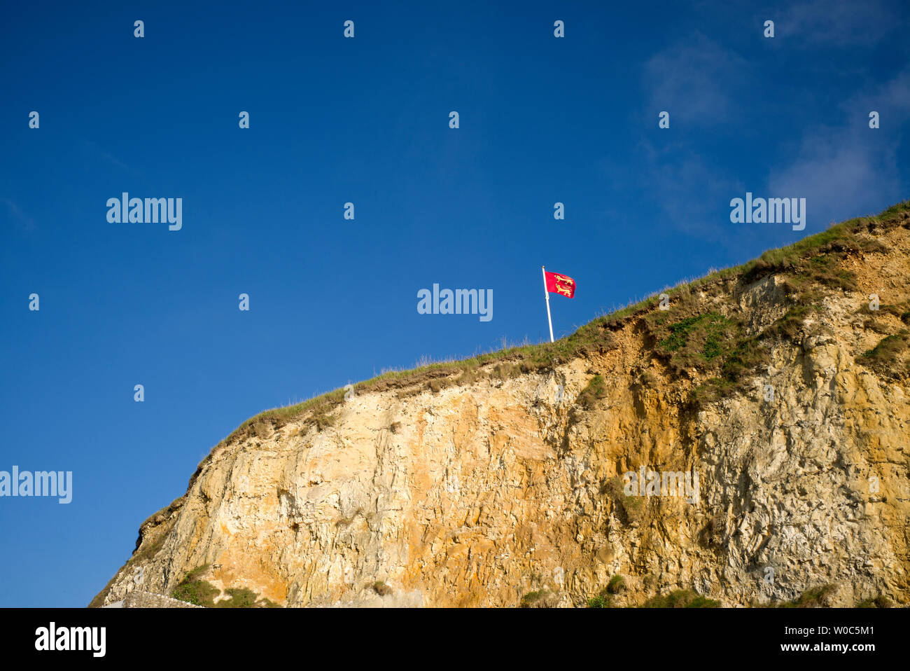 Flag flying above cliffs, Normandy, France Stock Photo