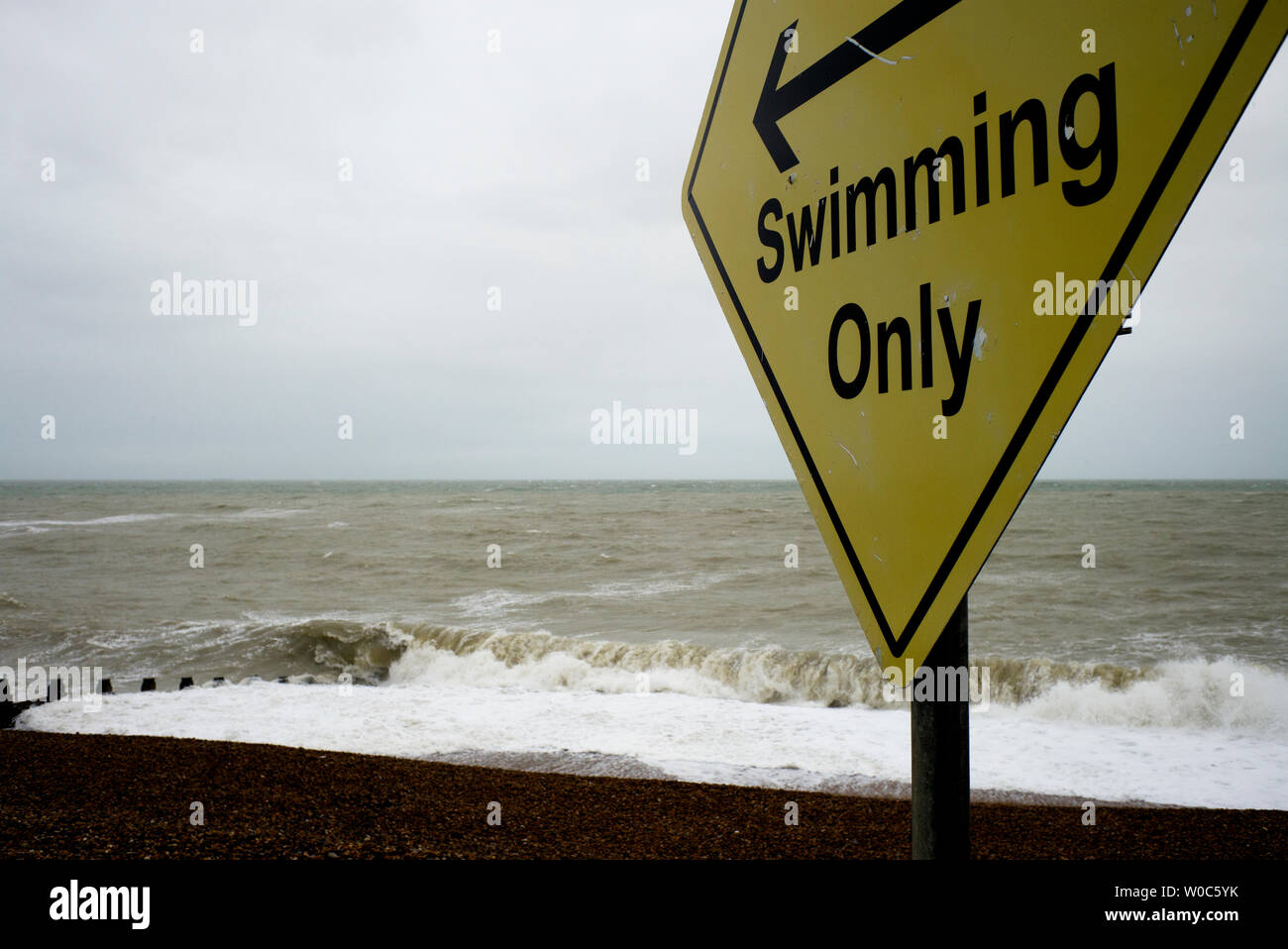 Swimming sign, empty beach, rough sea Stock Photo