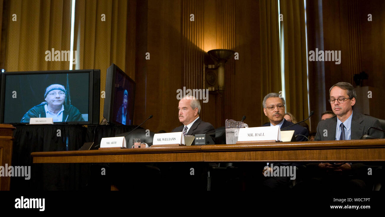 Professor Mark Hall, School of Law and Medicine, Wake Forest University, (R), Ron Williams, AETNA Chairman and CEO, (C), and Raymond Arth, president and CEO of Phoenix Faucets, (C) listen as Lisa Kelly (L) testifies via satellite before a Senate Finance Committee hearing on uninsured Americans on Capitol Hill in Washington on June 10, 2008. Lisa Kelly spoke about her ongoing battle with leukemia, her limited insurance plan, and the cost of her treatment. (UPI Photo/Patrick D. McDermott) Stock Photo