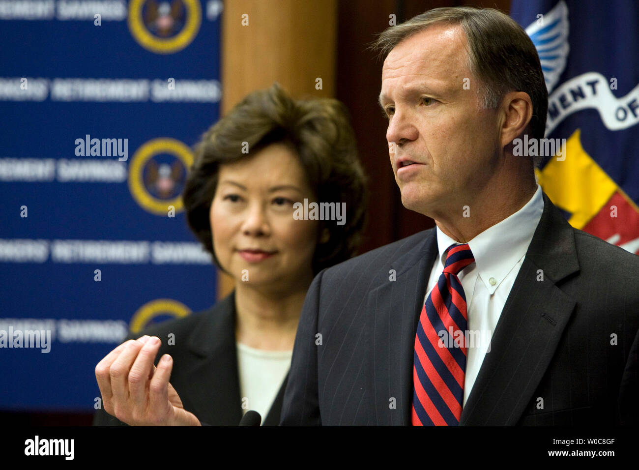 U.S. Department of Labor Secretary Elaine Chao (L) looks on as Securities and Exchange Commission Chairman Christopher Cox (R) delivers remarks during a signing ceremony of a Memorandum of Understanding between the Labor Department and the Securities and Exchange Commission in Washington on July 29, 2008. The agreement will protect an estimated $5.5 trillion in assets of retirement investors nationwide. (UPI Photo/Patrick D. McDermott) Stock Photo