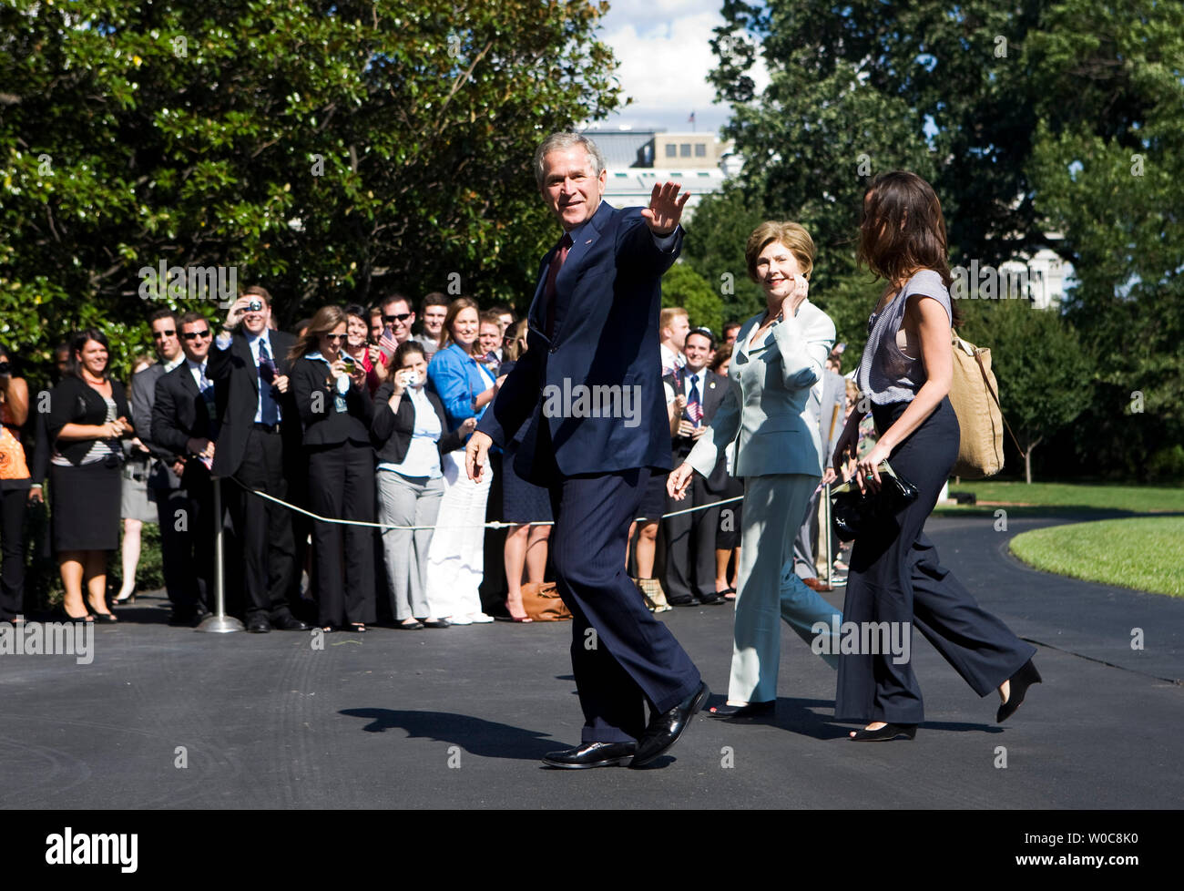 President George W. Bush waves as he walks with first lady Laura Bush and daughter Barbara Bush after returning to the White House in Washington on August 11, 2008. Bush has returned from attending some of the 2008 Olympics Games in Beijing. (UPI Photo/Patrick D. McDermott) Stock Photo