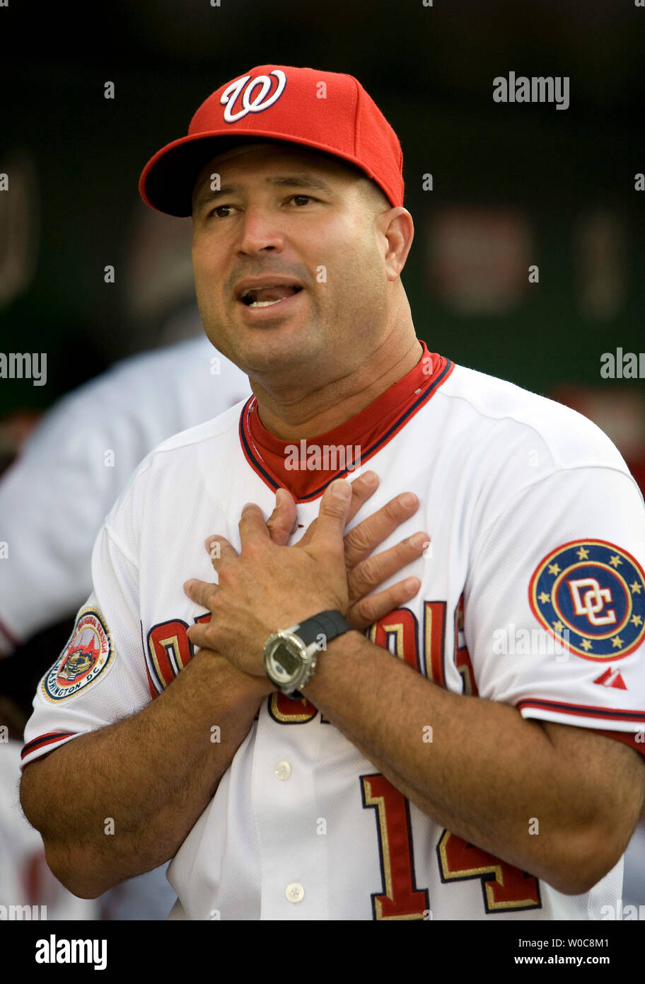 Manny Acta dons his jersey and hat after he was announced as the