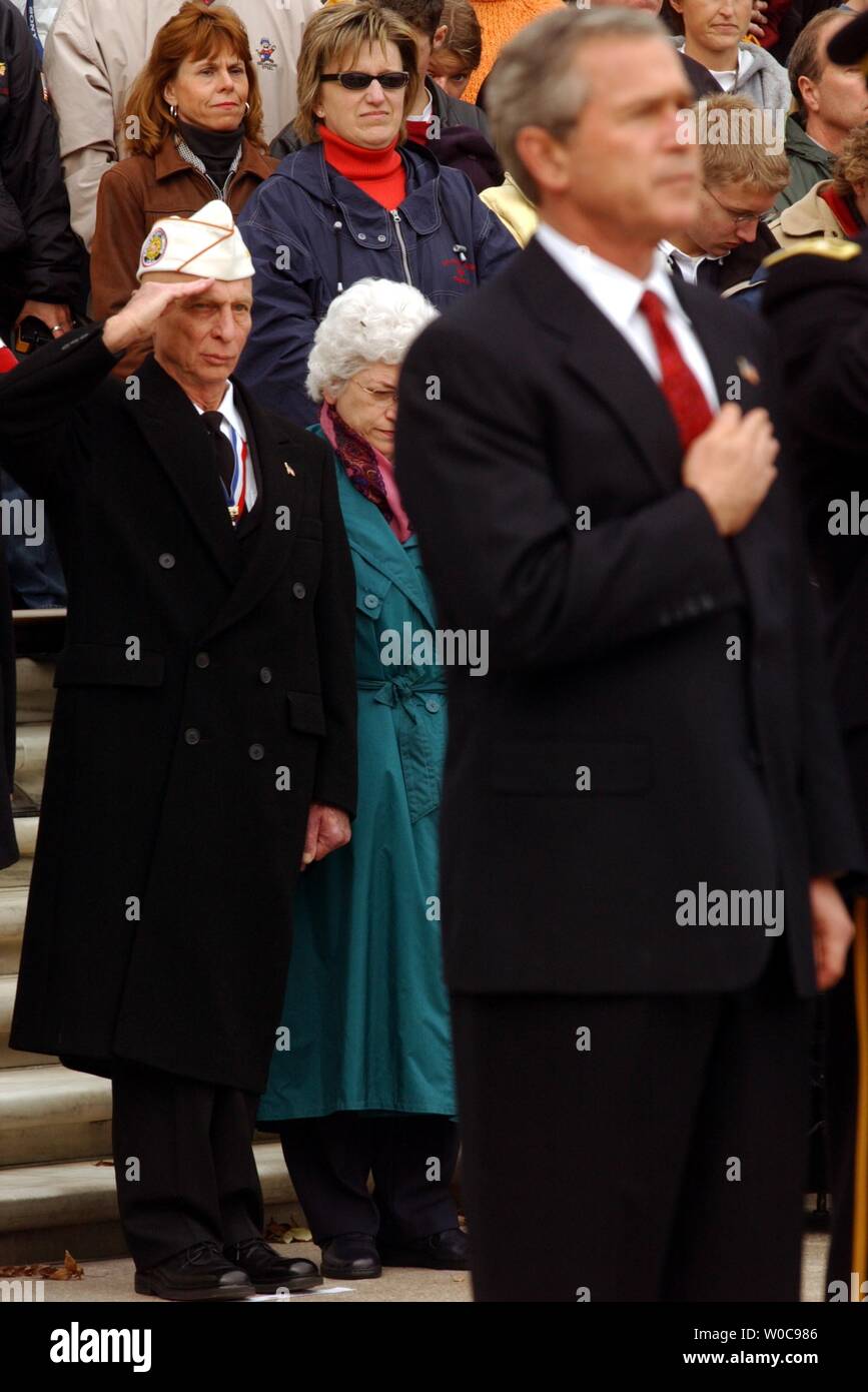 David Berger, National Commander of the Army and Navy Union, salutes during the playing of taps, as President George W. Bush covers his heart in a memorial ceremony at the tomb of the unknown soldier on Veterans Day, November 11, 2003 in Arlington National Cemetery in Arlington, Virgina. (UPI/Michael Kleinfeld) Stock Photo
