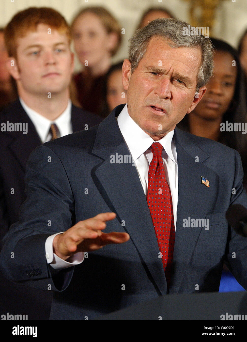 President George W. Bush  gestures during a ceremony honoring NCAA champion teams in the East Room of the White House on November 17, 2003. Present were University of Illinois-Champaign Men's Tennis, University of Florida Women's Tennis, University of Virginia Men's Lacrosse, Princeton's Women's Lacrosse, Rice University Men's Baseball, UCLA Women's Softball, Clemson University Men's Golf, and University of Southern California Women's Golf.   (UPI Photo/Roger L. Wollenberg) Stock Photo
