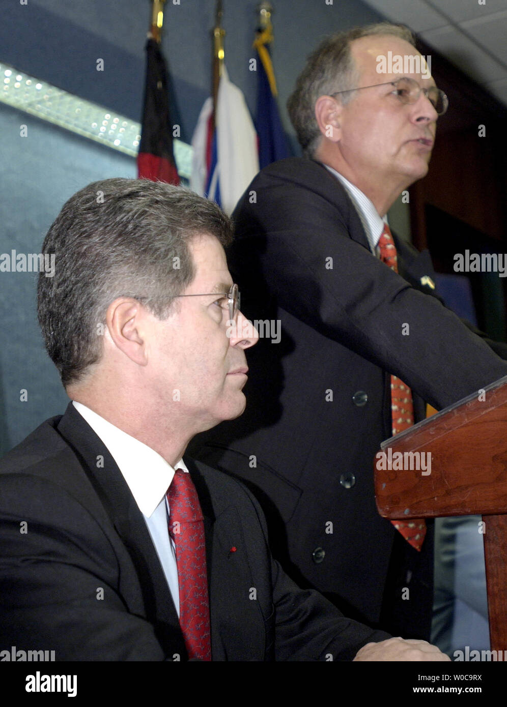 French Ambassador to the United States Jean David Levitte left, listens in as German Ambassador to the United States Wolfgang Ischinger anwsers a reporter's question during an anouncement of a new program between the United States, France and Germany at the National Press Club on December 12, 2003 in Washington.  Both gentlemen tried to avoid questions regarding the decision by the United States to keep companies from their countries from gaining  contracts in Iraq. (UPI Photo/Michael Kleinfeld) Stock Photo