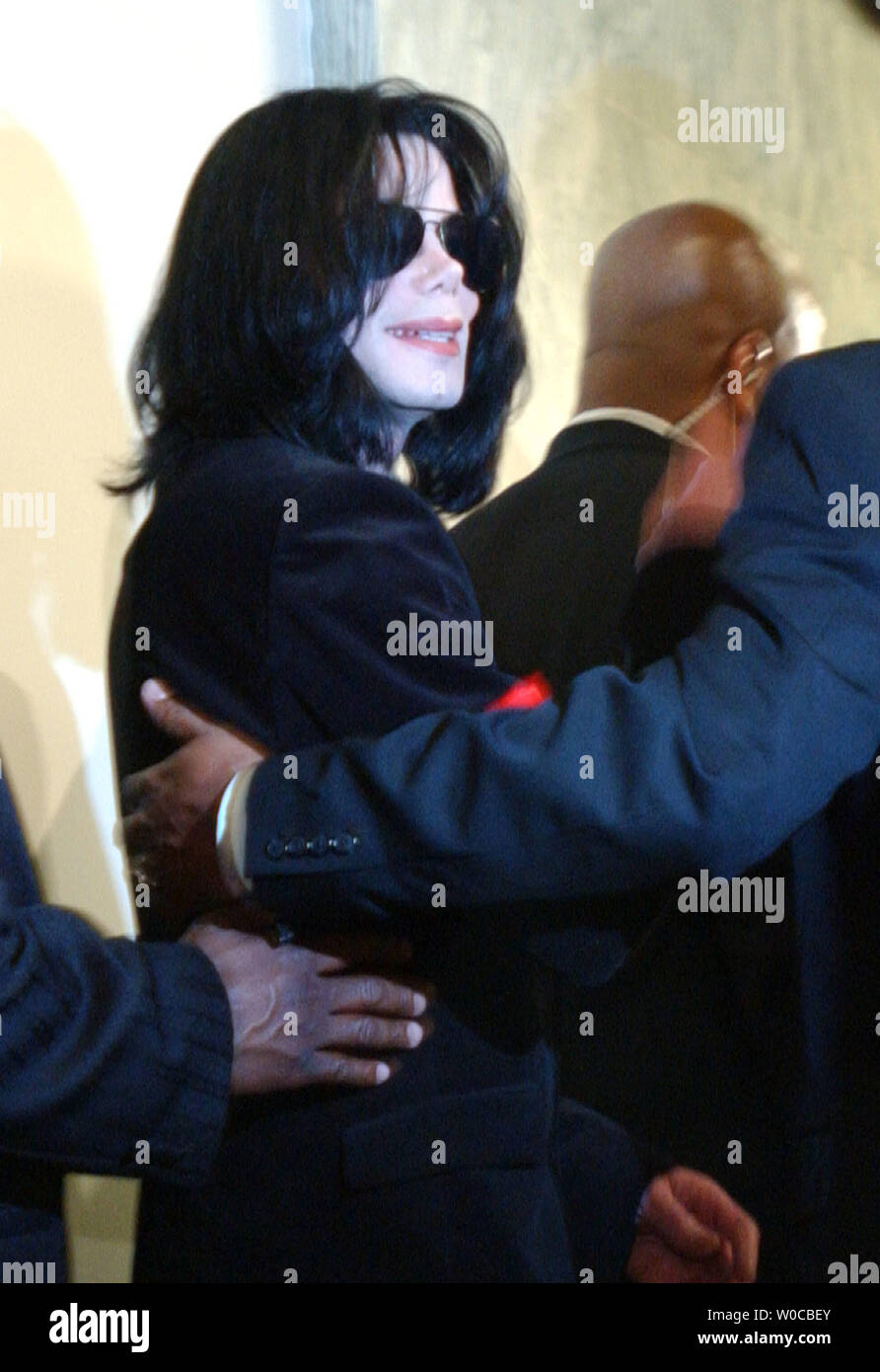 Michael Jackson, surrounded by security, exits from a meeting with black Congressional members on Capitol Hill in Washington on March 30, 2004. Jackson did not speak to the press, but in a statement he asked Congress to keep working on improving AIDS treament, healthcare, education and unemployment, especially in what he called 'our sister continent,' Africa.    (UPI Photo/Roger L. Wollenberg) Stock Photo