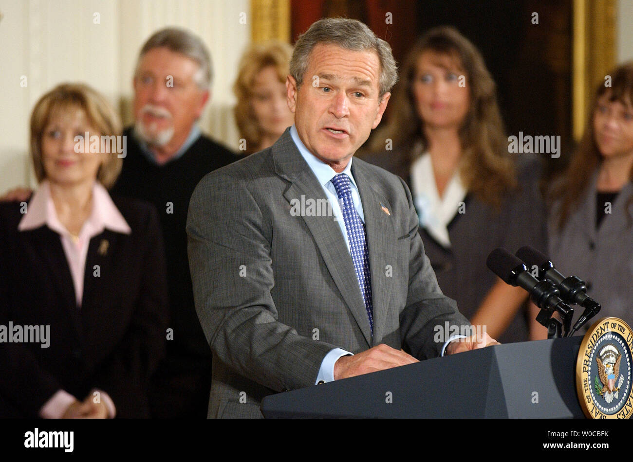 President George W. Bush speaks before signing the Unborn Victims of Violence Act of 2004 during a ceremony in the East Room of the White House on April 1, 2004. Behind Bush are, left to right, Laci Peterson's parents Sharon Rocha and Ron Grantski, Cynthia Warner Tracy Marciniak-Seavers, and Stephanie Alberts.    (UPI Photo/Roger L. Wollenberg) Stock Photo