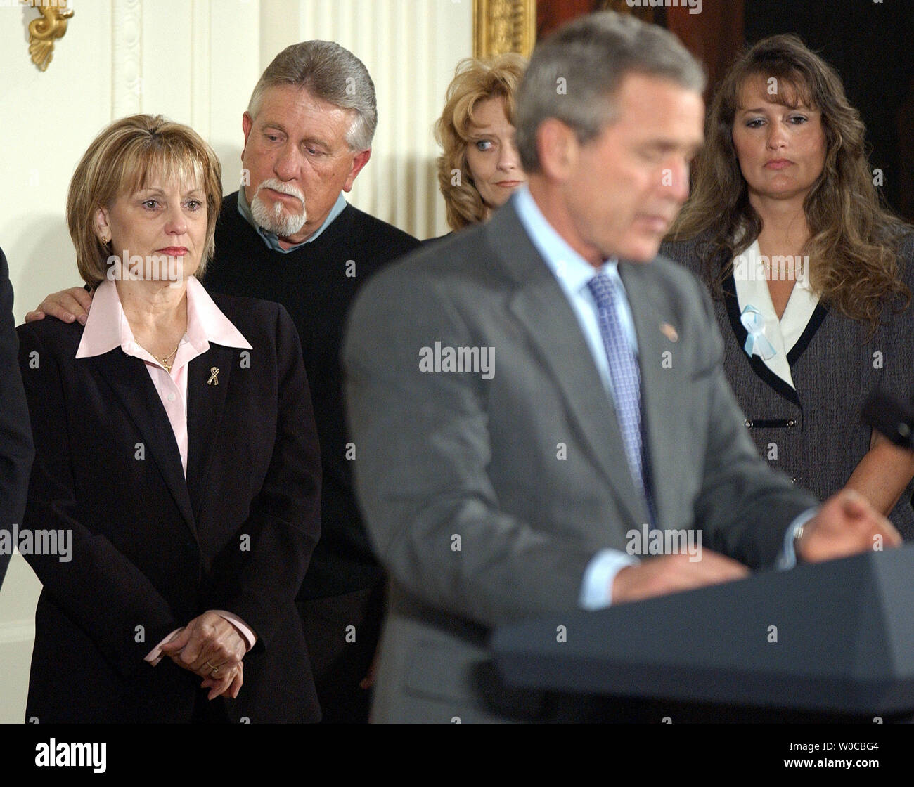 President George W. Bush speaks before signing the Unborn Victims of Violence Act of 2004 during a ceremony in the East Room of the White House on April 1, 2004. Behind Bush are, left to right, Laci Peterson's parents Sharon Rocha and Ron Grantski, Cynthia Warner Tracy and Marciniak-Seavers.   (UPI Photo/Roger L. Wollenberg) Stock Photo