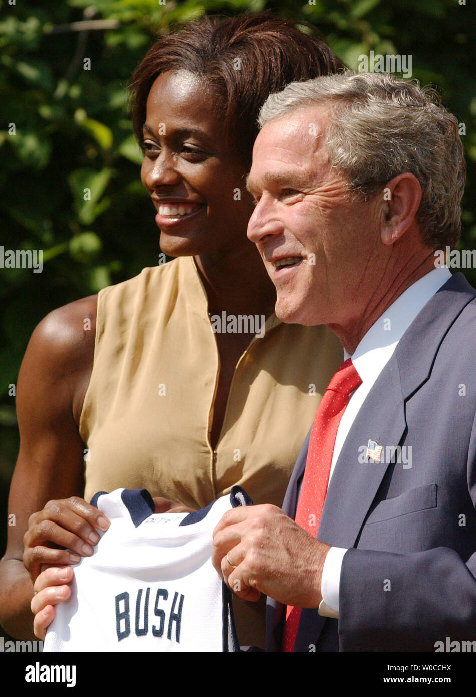 President George W. Bush recieves a team shirt from Swin Cash, a player ...