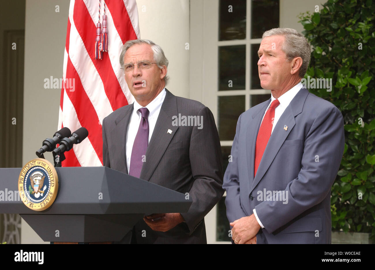 Rep. Porter Goss, R-FL, speaks to members of the press after President George W. Bush, left, announced that he will be his nominee as the new head of the CIA, on August 10, 2004 in Washington. Goss is a former member of the CIA and sits on the House of Representatives Intelligence Committee. (UPI Photo/Michael Kleinfeld) Stock Photo
