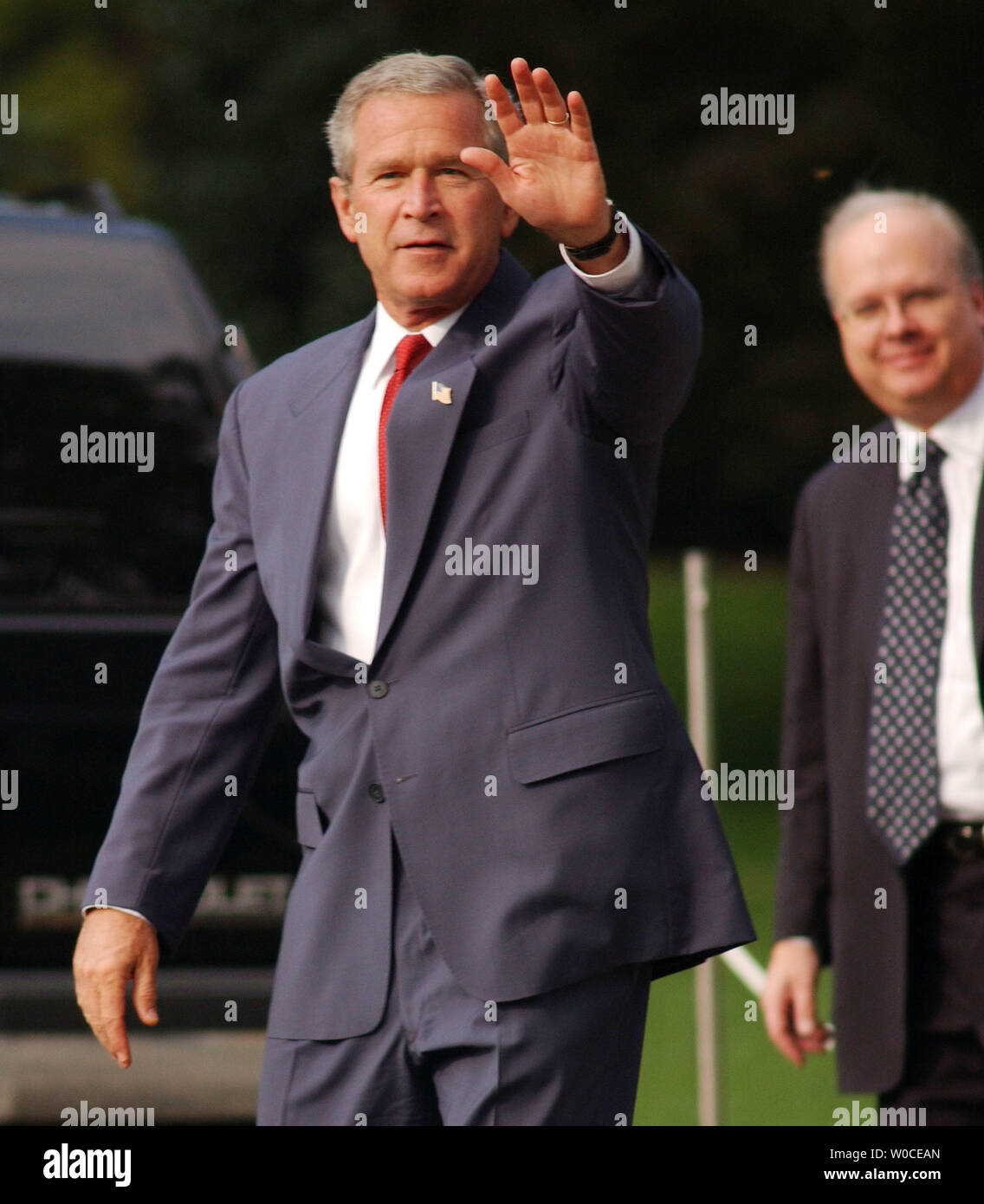 President George W. Bush waves to the press while walking across the South Lawn of the White House on August 10, 2004 in Washington.  Bush had just announced that he is nominating Rep. Porter Goss, R-FL, as the new head of the CIA. Goss is a former member of the CIA and sits on the House of Representatives Intelligence Committee. (UPI Photo/Michael Kleinfeld) Stock Photo