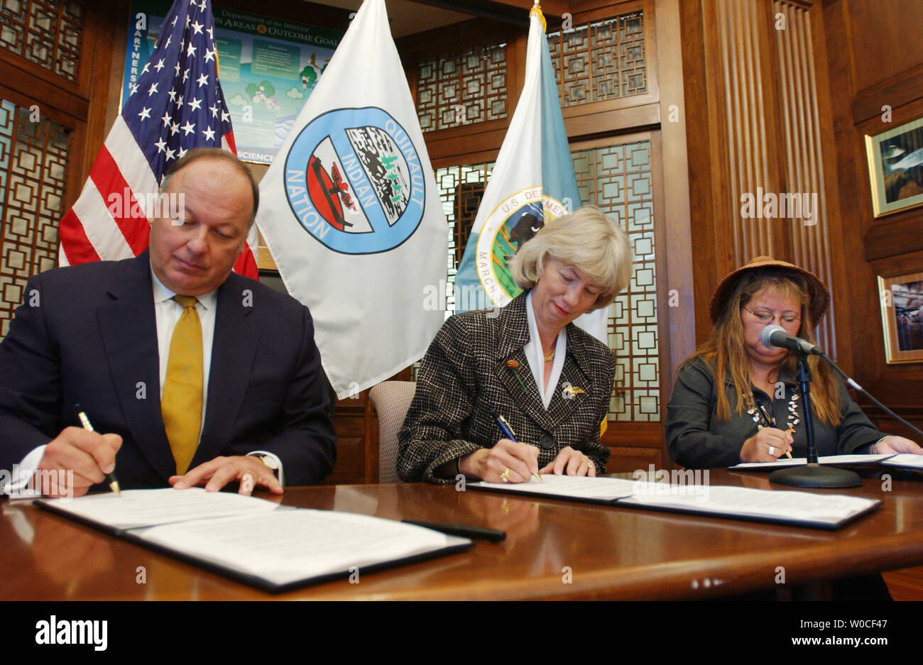 Secretary of the Interior Gale Norton signs the proper documents with Pearl Capoeman-Baller, President, Quinault Indian Nation, and Assistant Attorney Gen. Thomas Sansonetti, during a signing ceremony to preserve more than 4,000 acres of forest habitat for the endangered marbled murrelet and give back areas of tribal land to the Quinault Indian Nation, on September 20, 2004 in Washington. (UPI Photo/Michael Kleinfeld) Stock Photo