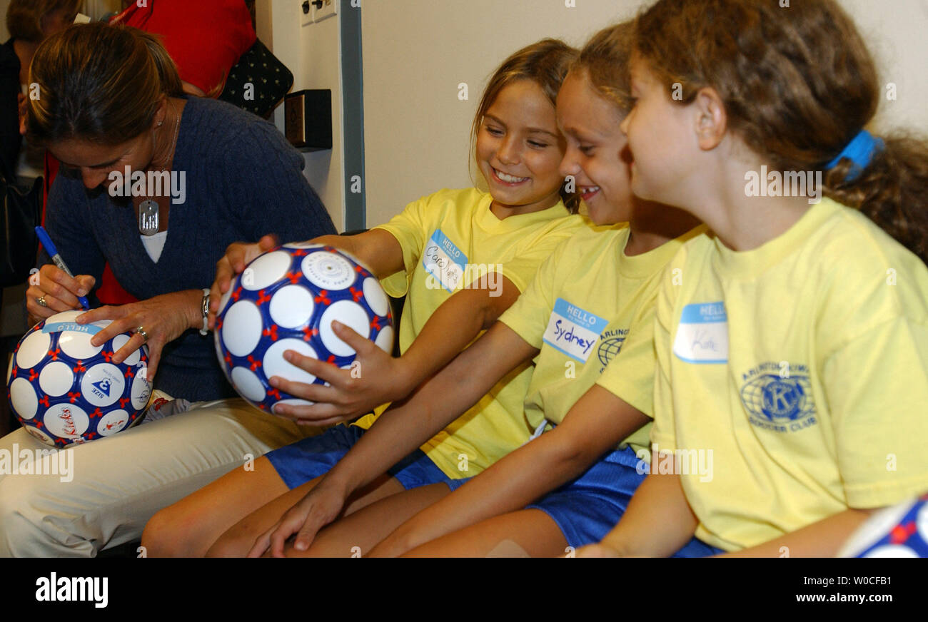 Olympic Gold Medalist in soccer Brandi Chastain autographs balls for a group of young female soccer players from Arlington County, Va., during an event on Capitol Hill in Washington on Sept. 28, 2004. From left to right are Carloline, Sydney and Katie.    (UPI Photo/Roger L. Wollenberg) Stock Photo