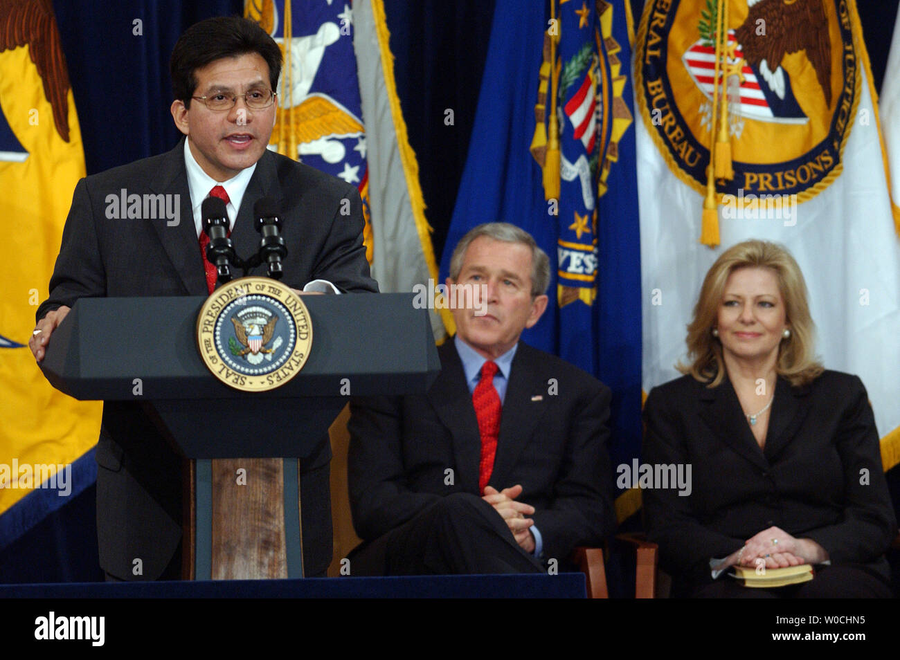 Attorney General Alberto Gonzales speaks, as U.S. President George W. Bush and Gonzales' wife Rebecca look on, after the Attorney General's swearing-in ceremony at the Justice Department in Washington on Feb. 14, 2005.   (UPI Photo/ROGER L. WOLLENBERG) Stock Photo
