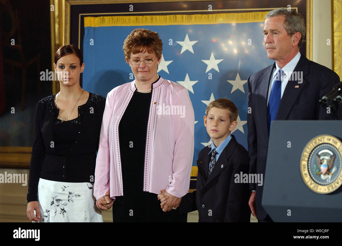 Jessica, Brigit and David Smith (l to r), the family of Army Sgt. 1st Class Paul  Ray Smith, and U.S. President George W. Bush listen as a citation is read  bestowing the