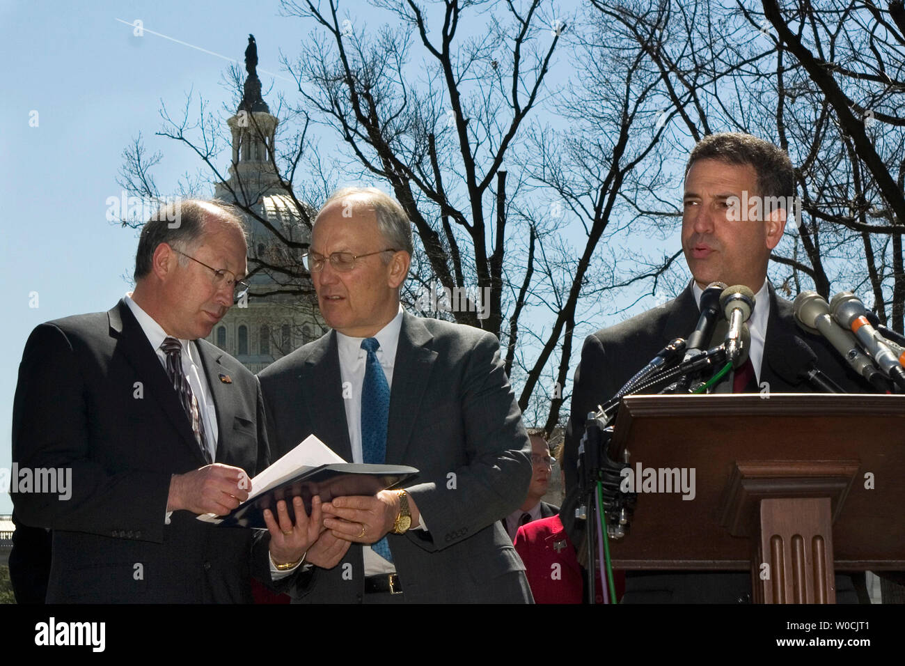 US Senators Ken Salazar, D-CO, back left, and Larry Craig, R – ID, confer as US Senator , Russ Feingold, D-WI, right, speaks speaks to the press on Capitol Hill about the adoption of a bipartisan bill to revise several particularly controversial provisions of the Patriot Act, Tuesday, April 5, 2005, in Washington. (UPI Photo/Kamenko Pajic) Stock Photo