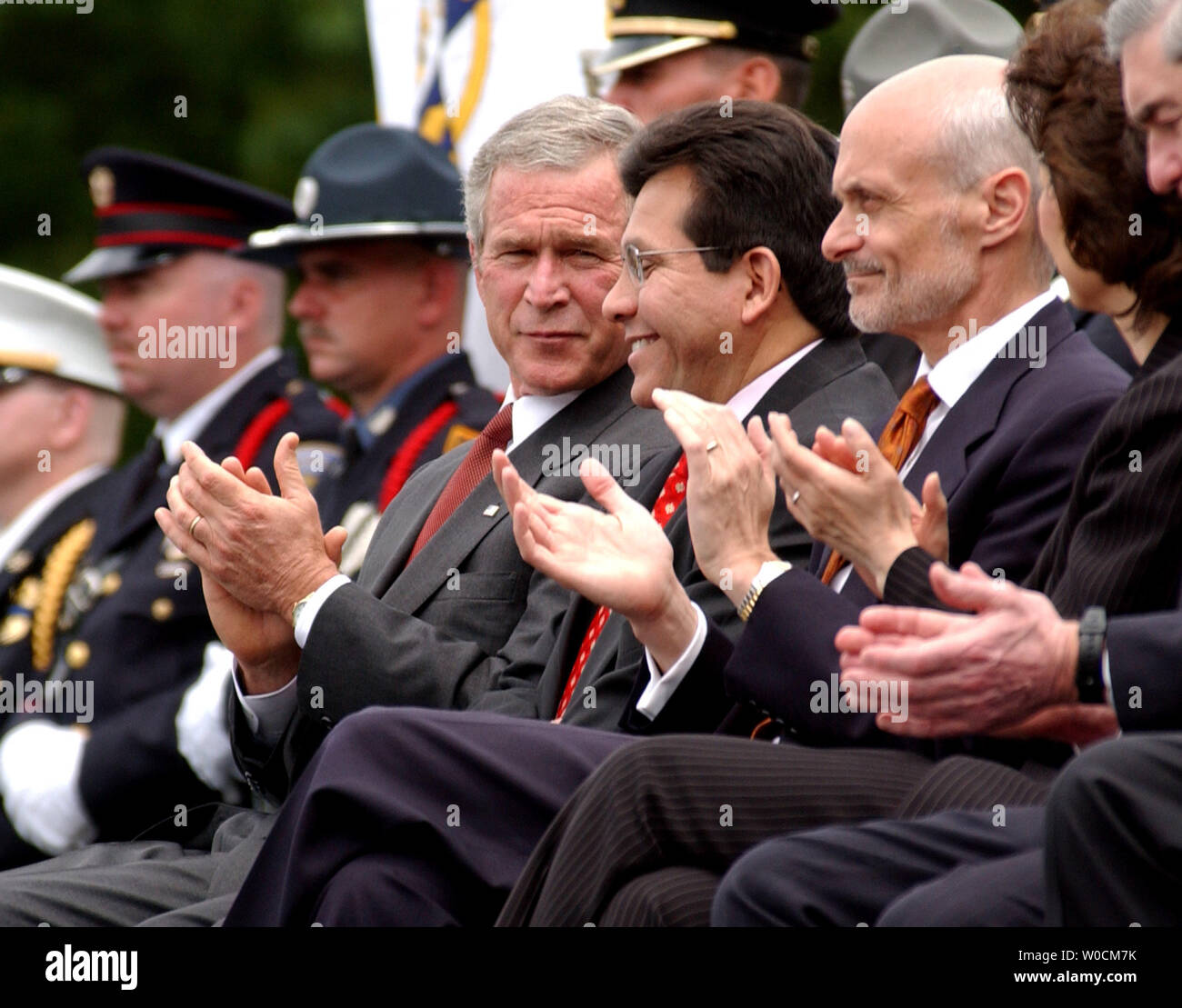 President George W. Bush speaks with Attorney General Alberto Gonzales, right, during the Annual Peace Officers' Memorial Service on May 15, 2005 at the Capitol building in Washington. Secretary of Homeland Security Michael Chertoff sits to their right.     (UPI Photo/Michael Kleinfeld) Stock Photo