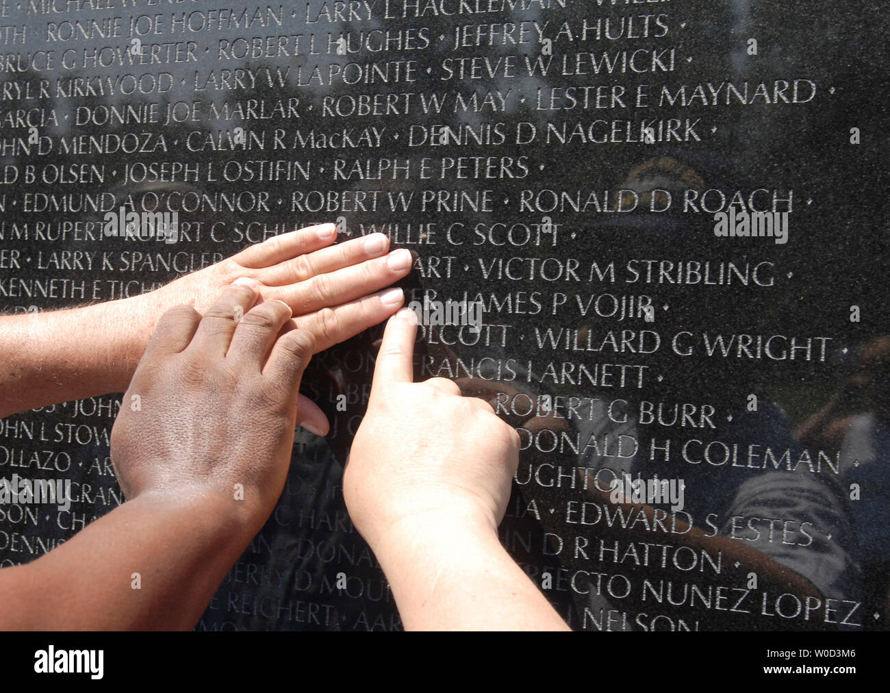 Vietnam Veterans John Broton, Cloise Orand and Leonard 'Doc' Brooks search for the names of their fallen comrades, who were killed during an ambush in Vietnam in 1968, at the Vietnam Veterans Memorial in Washington on May 29, 2006. (UPI Photo/Kevin Dietsch) Stock Photo
