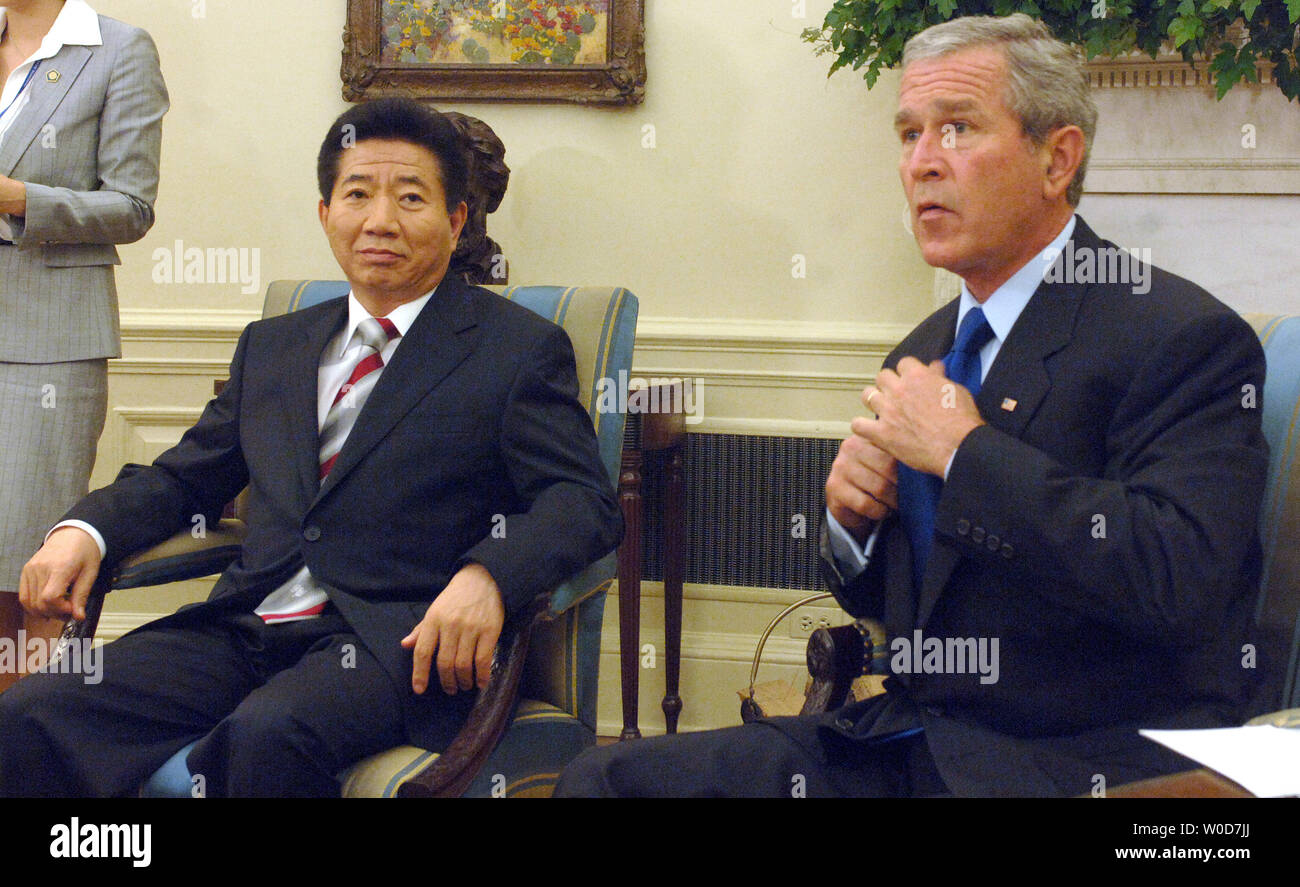 U.S. President George W. Bush adjusts his tie before speaking with the ...