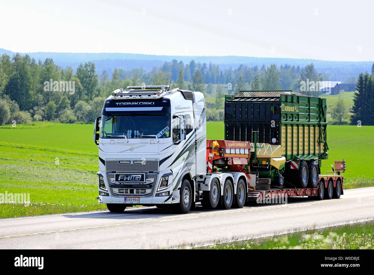 Jamsa, Finland. June 6, 2019. Volvo FH16 semi trailer Tornikoski hauls Krone AX 310 GL forage wagon through Finnish countryside in the summer. Stock Photo
