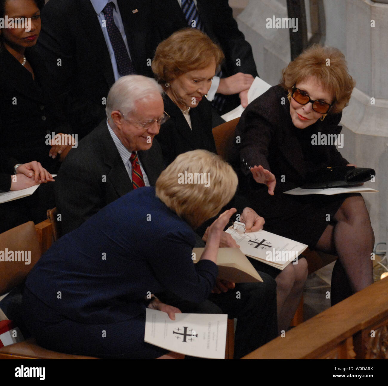 Lynne Cheney (L) leans over former President Jimmy Carter and wife Rosalyn to greet Nancy Reagan before the State Funeral  held for former President Gerald R. Ford at Washington National Cathedral in Washington on January 2, 2007. Ford passed away on December 26, 2006 at the age of 93.  (UPI Photo/Roger L. Wollenberg) Stock Photo