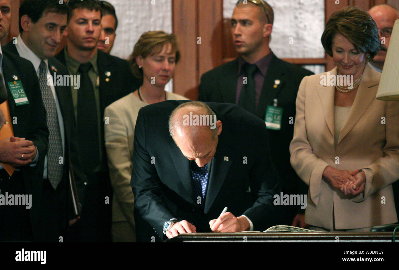 Israeli Prime Minister Ehud Olmert (C) signs the House Office guest book as House Speaker Nancy Pelosi (D-CA)(R) looks on after a meeting on Capitol Hill on June 19, 2007.  (UPI Photo/Dominic Bracco II) Stock Photo