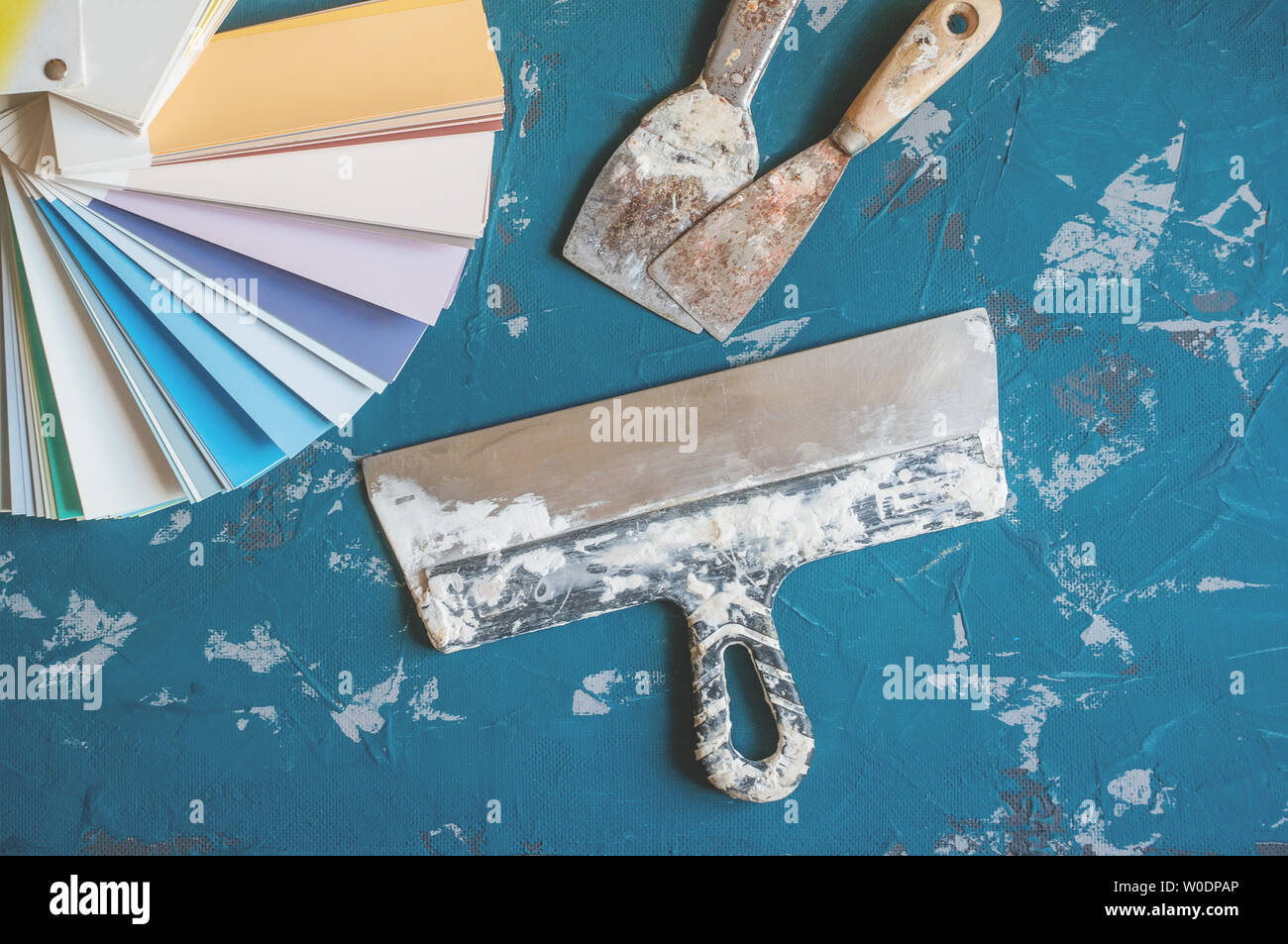 Select the color of paint for the walls. Old tools for painting and putty walls and backgrounds. Making background. Stock Photo