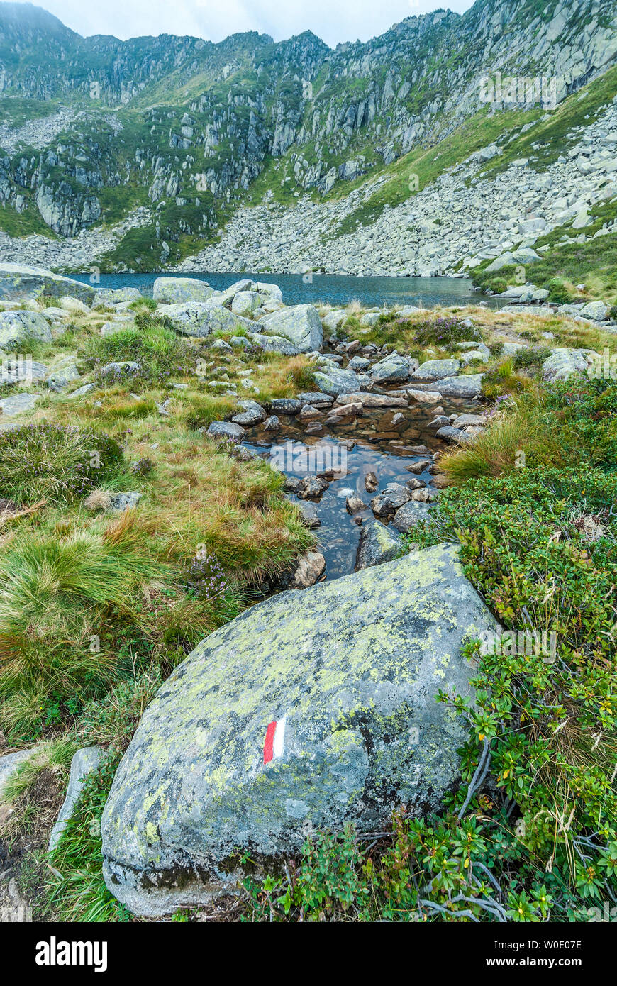 France, Pyrenees Ariegeoises Regional Nature Park, hiking of the lakes of Bassiès, GR 10 marks on a rock and the Alate pond Stock Photo