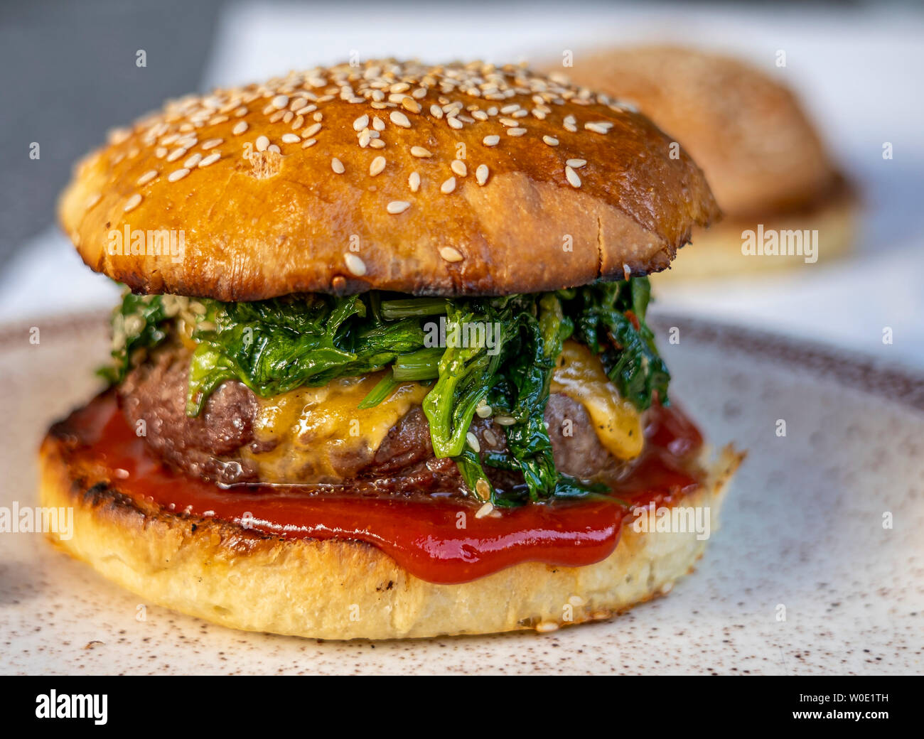 cheeseburger with beef patty, spinach, red sauce, cheddar cheese piled