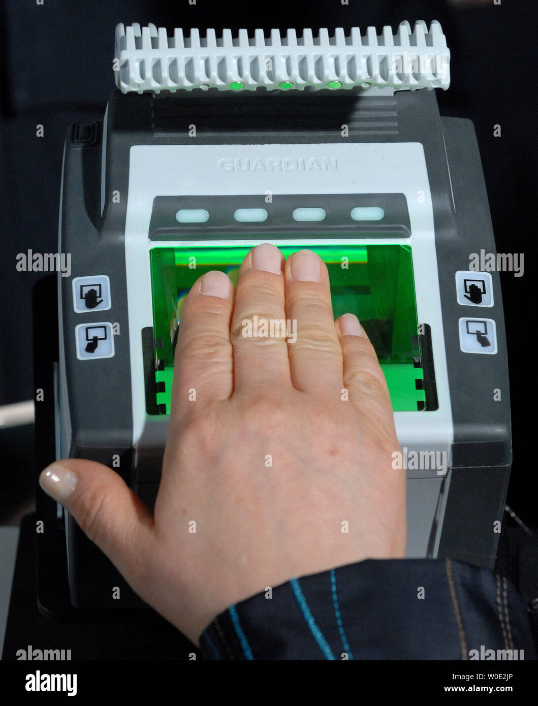 A Korean visitor to the United States has their fingerprints scanned by the Cross Match Technologies L SCAN GUARDIAN scanner that obtains all 10 fingerprints of international visitors entering the U.S. through customs at Dulles International Airport in Dulles, Virginia, on December 10, 2007. The DHS plans to deploy the ten-fingerprint scanners, up from current two-print scanners, at all U.S. points of entry over the next year.    (UPI Photo/Roger L. Wollenberg) Stock Photo