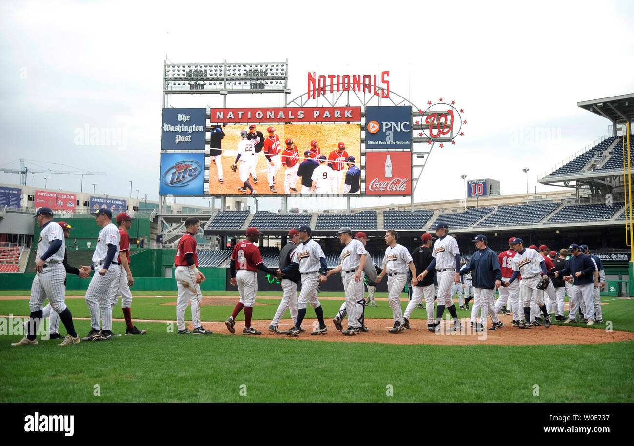 Members of the George Washington University and Saint Joseph's University  baseball team shake hands with each other after the two teams played the  first game at the Washington Nationals new stadium in