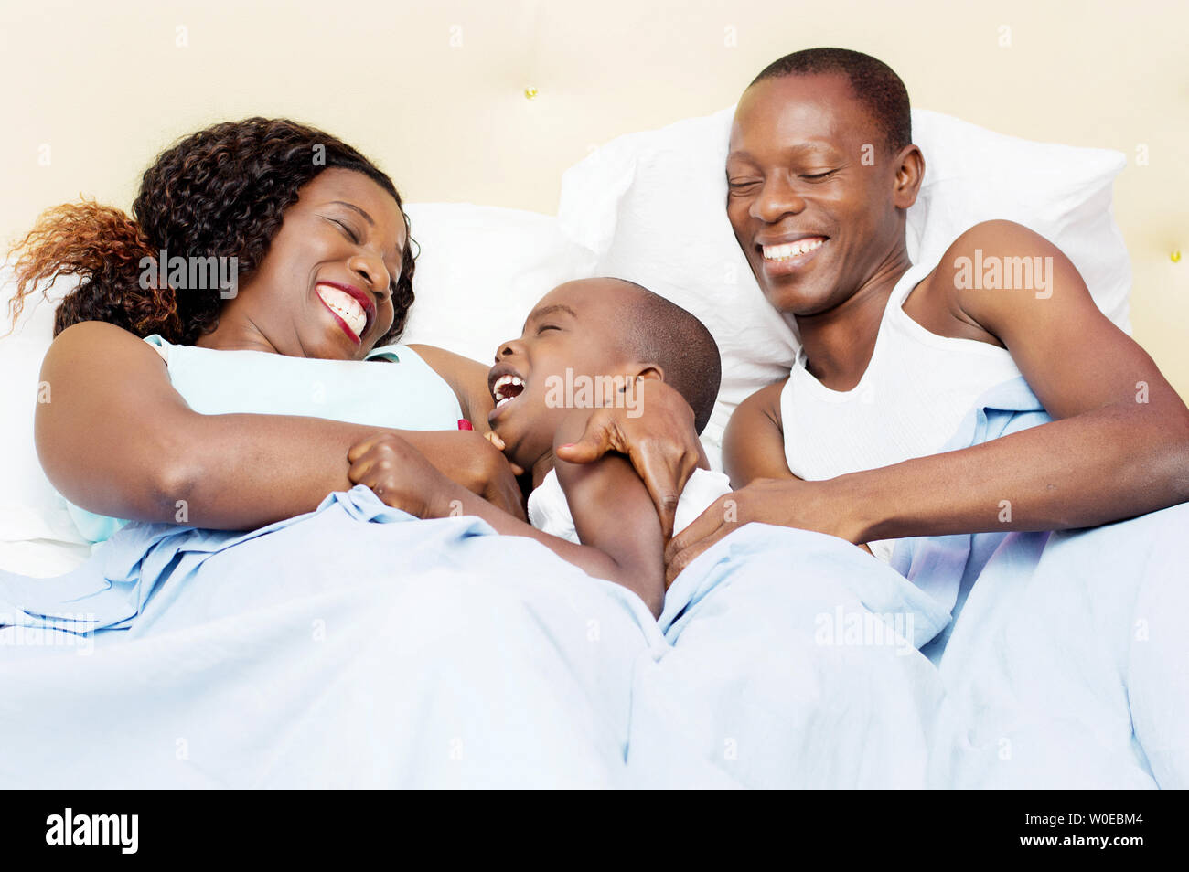 this family lying in bed is happy to share good holiday together Stock Photo