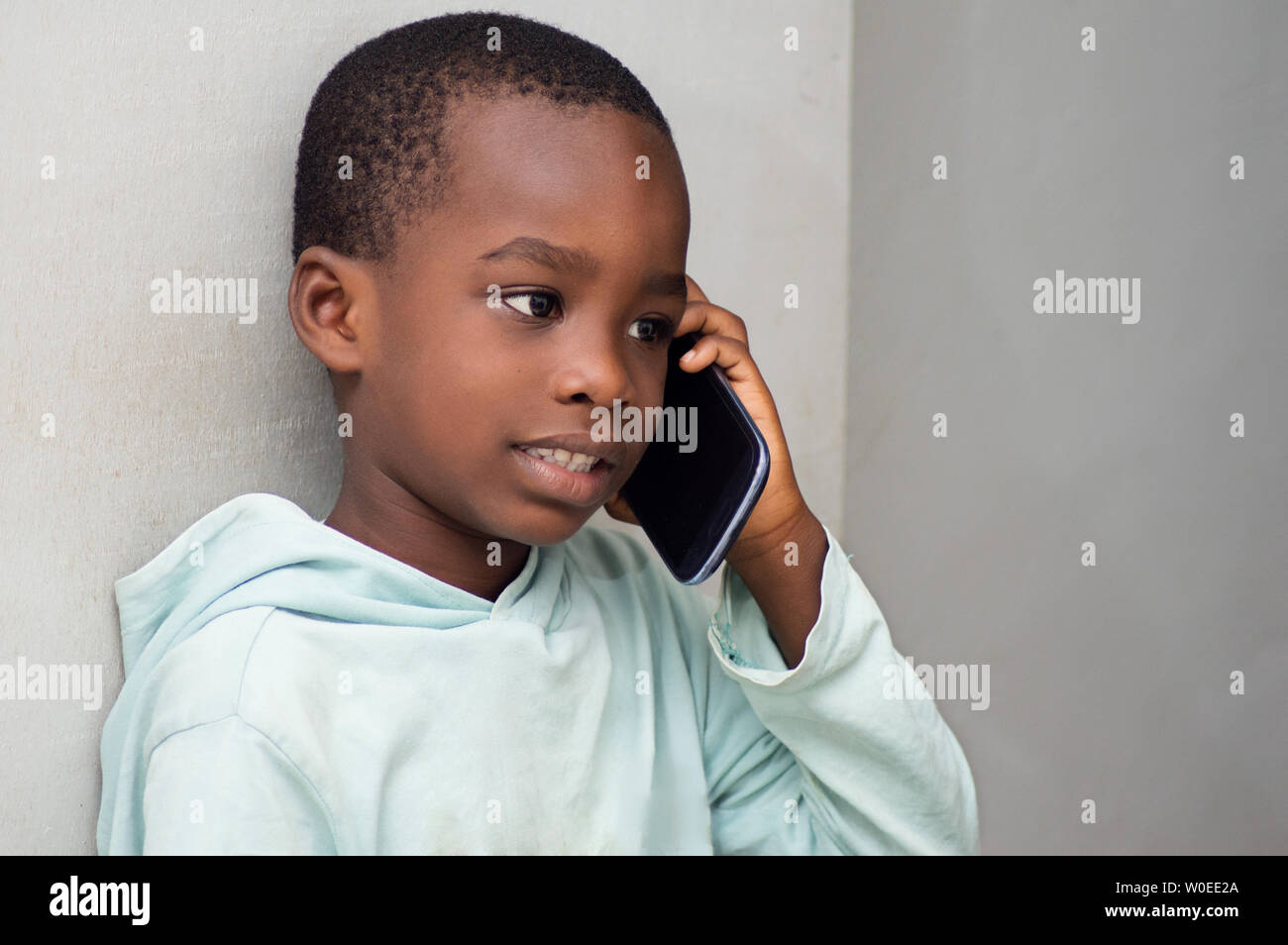 This child on the phone, listening intently his interlocutor. Stock Photo