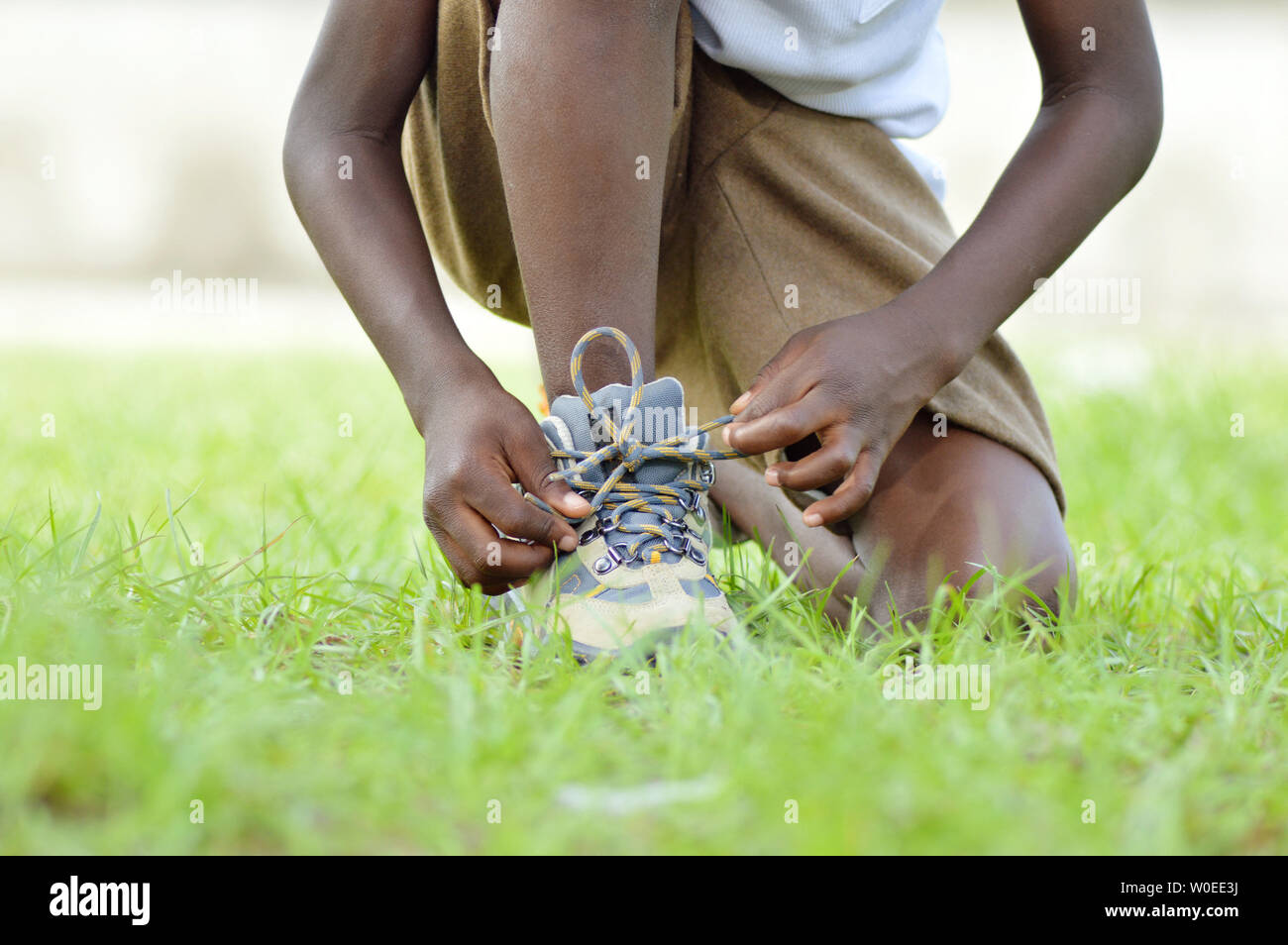 A child knee, tie his shoes lances to run better. Stock Photo